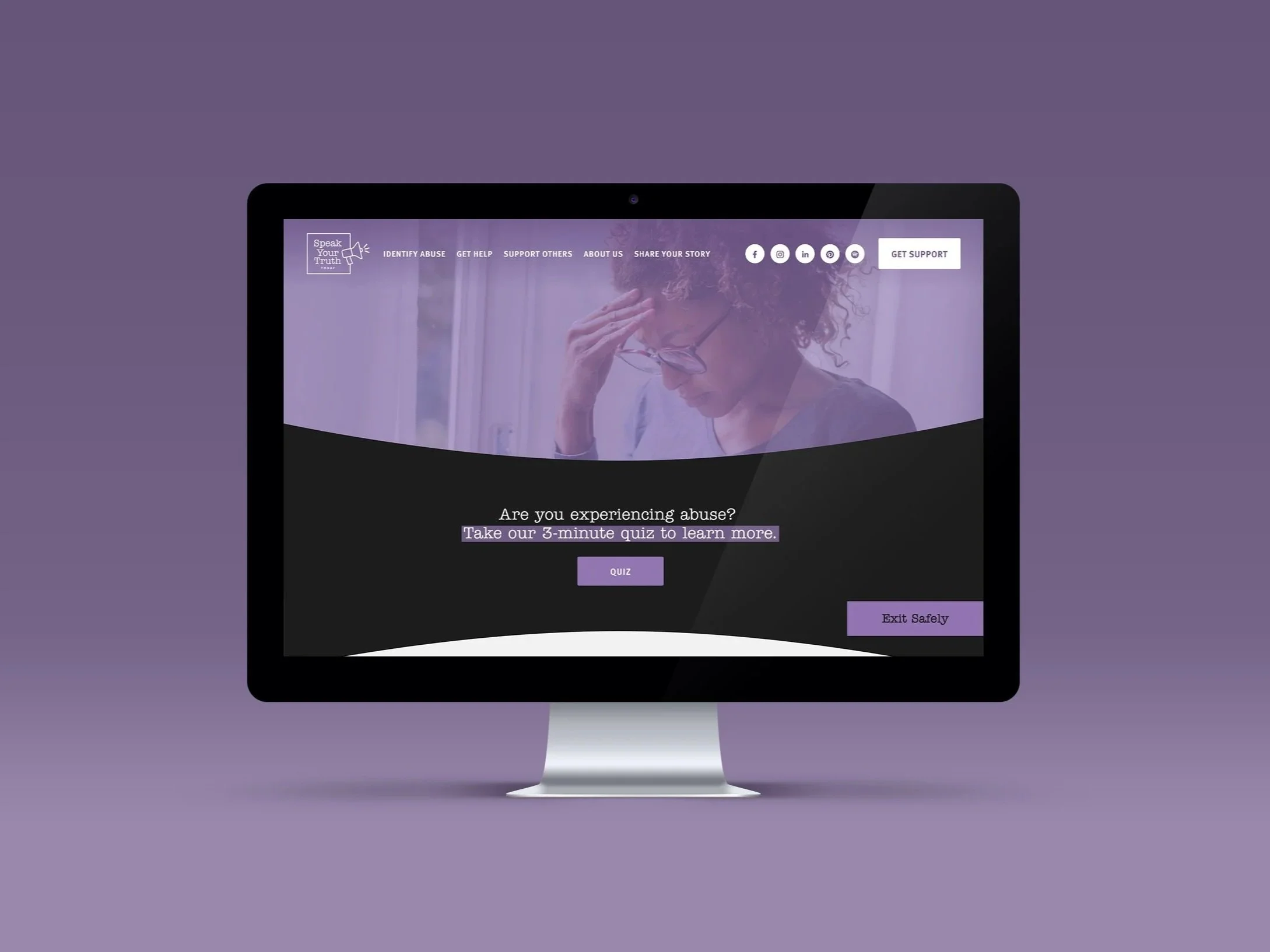 A computer monitor displaying a website called 'Speak Your Truth' with navigation options, social media icons, and a purple-themed design about experiencing abuse and taking a quiz.
