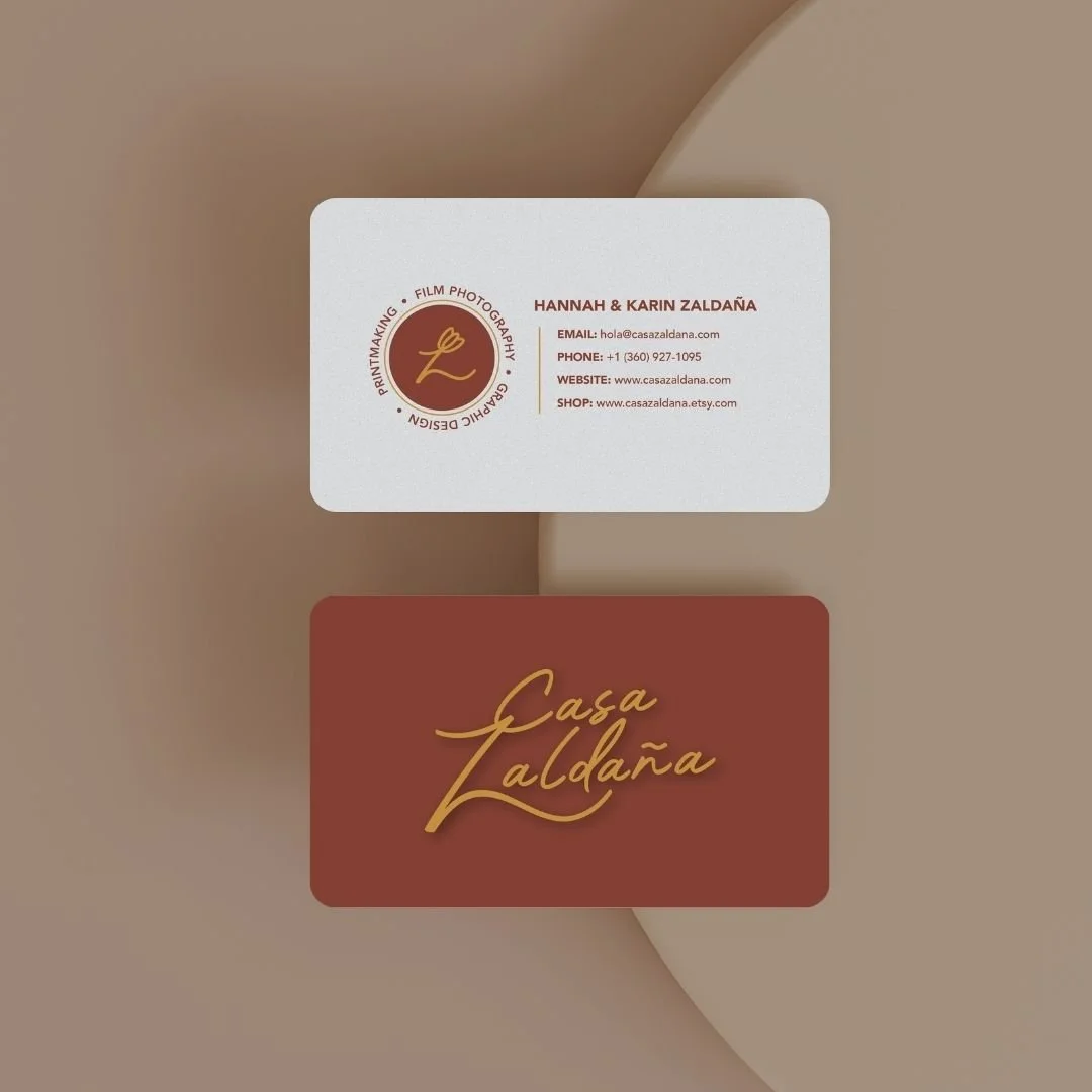 Business card with logo and contact information for Hannah & Karin Zaldaya, featuring a brown and gold logo with a cursive 