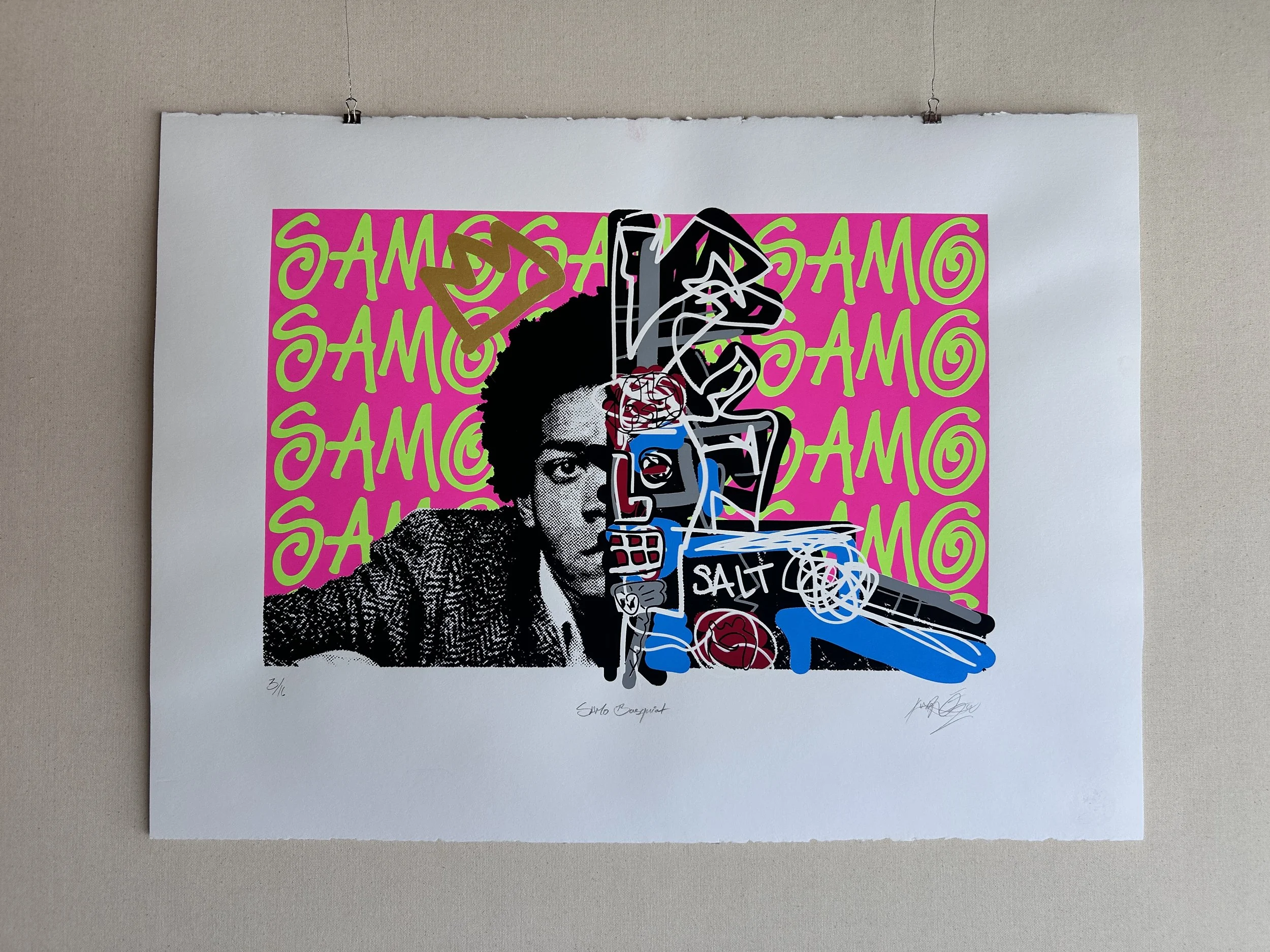 Art print featuring a stylized black and white portrait of a man with an afro hairstyle, over a pink background with green, stylized repeating text 'SAMO'. Handwritten signatures and edition number at the bottom.