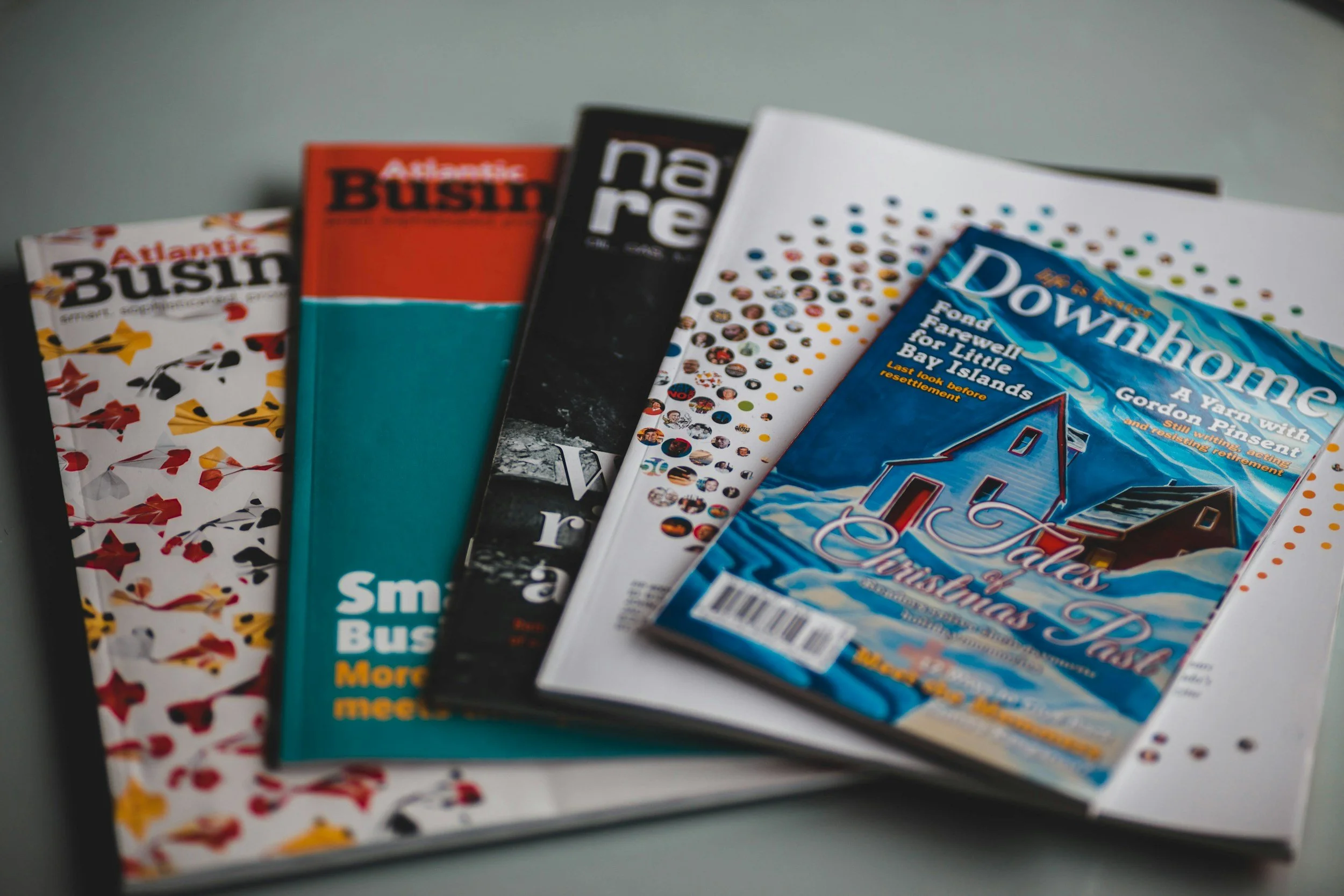 A collection of magazines and brochures, including Atlantic Business, with various cover designs and titles visible.