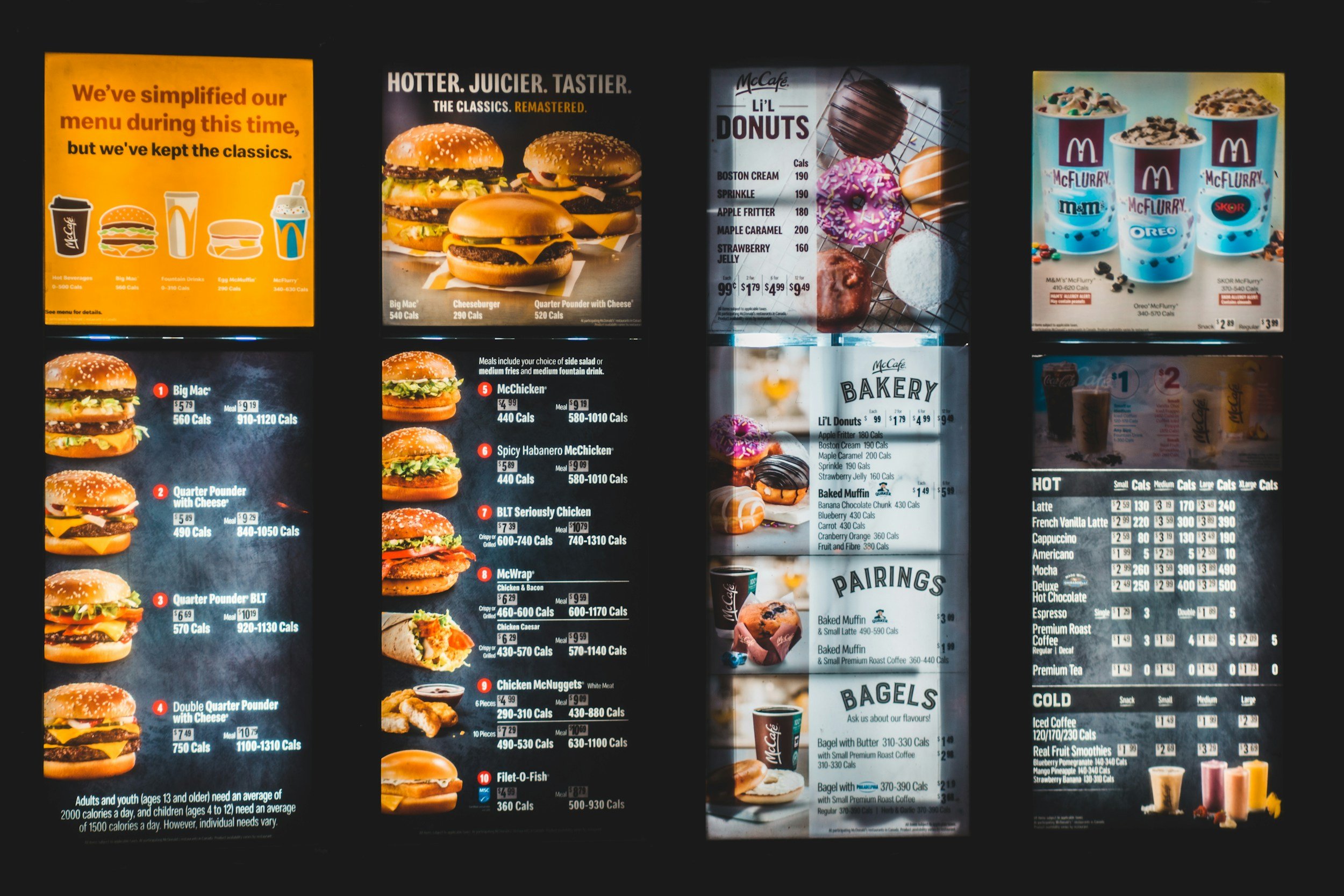 A brightly lit McDonald's menu board displaying various food and beverage options including burgers, fries, desserts, and drinks.
