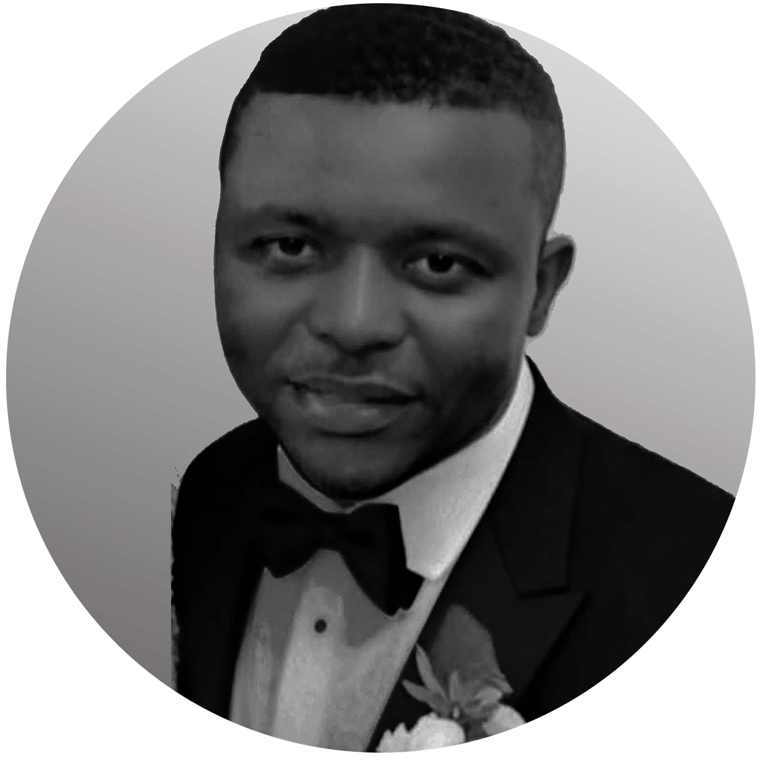 A young man in a tuxedo with a bow tie, looking at the camera, with short hair and a serious expression.