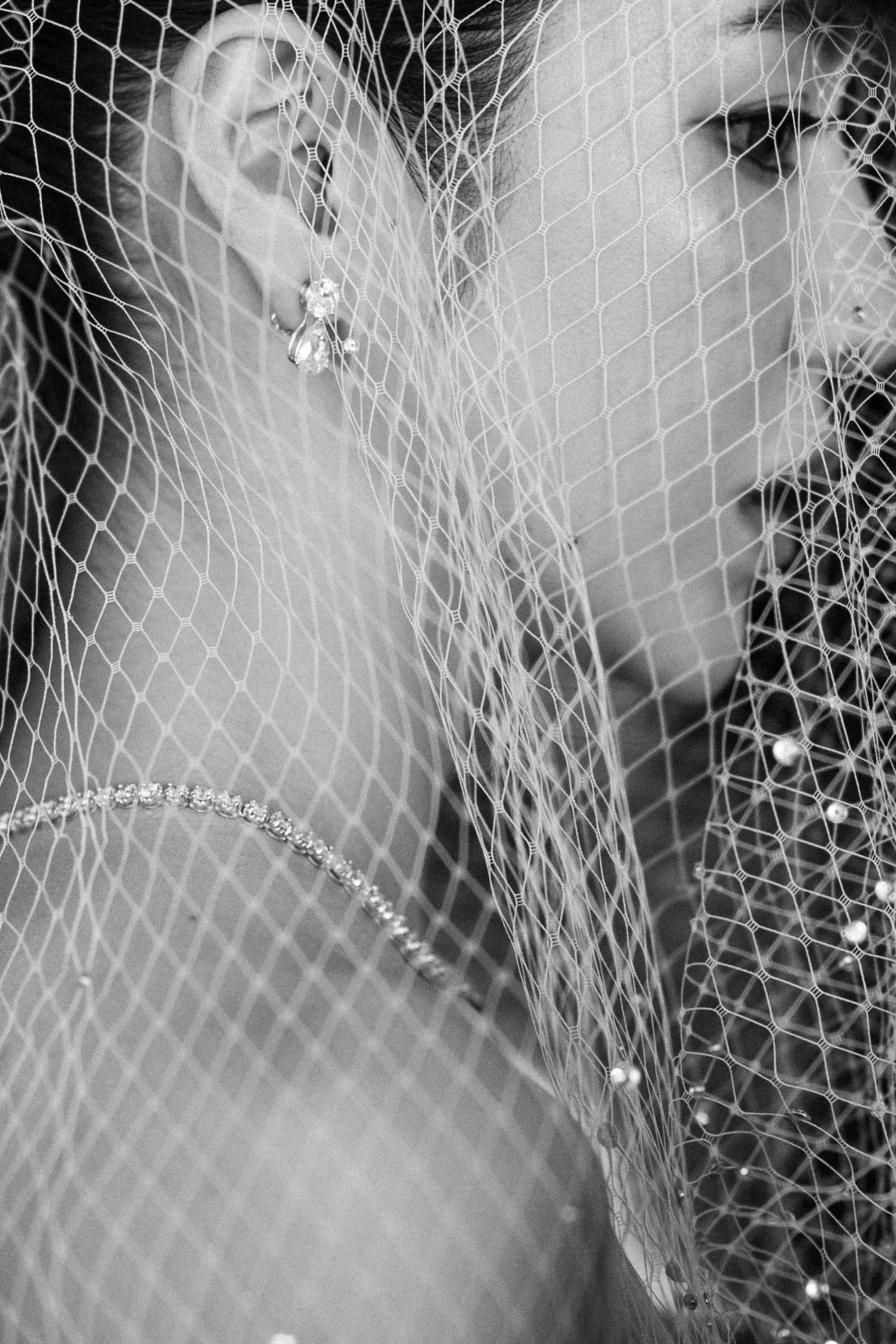 Bride wearing a birdcage veil before getting ready.