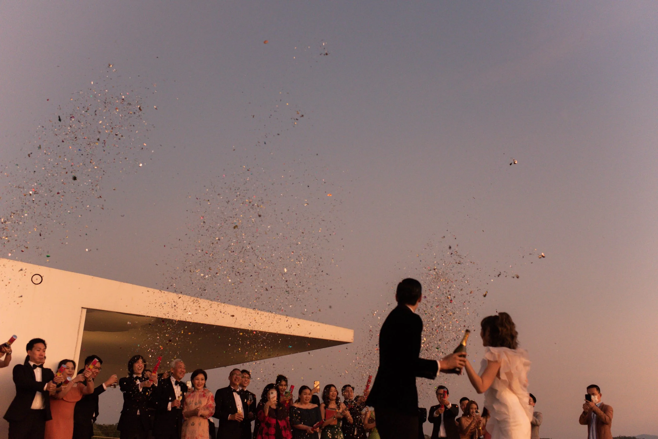 Guests throwing paper confetti after the bride and groom share words with each other.