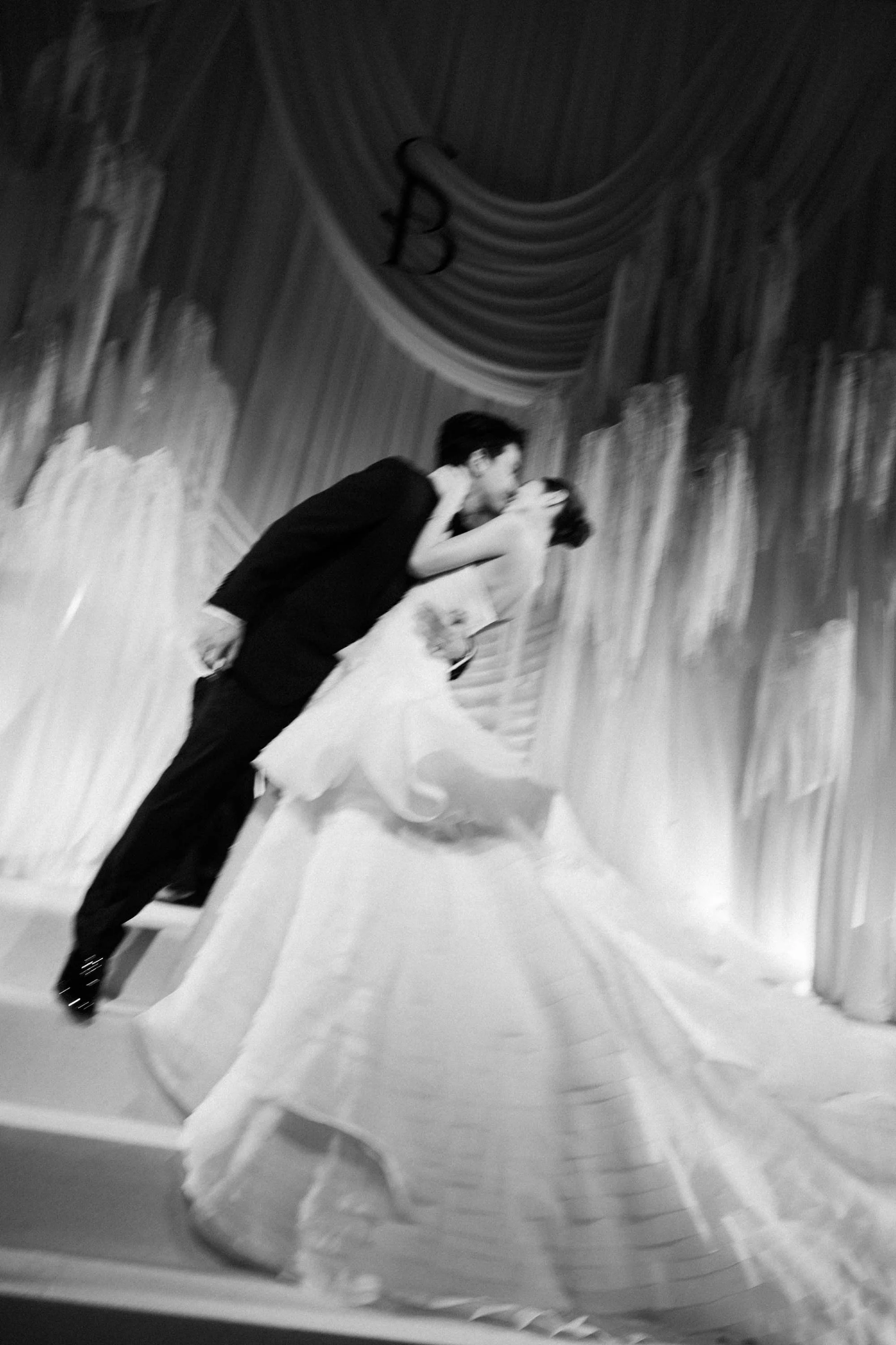Bride and groom posing together on the reception stage.
