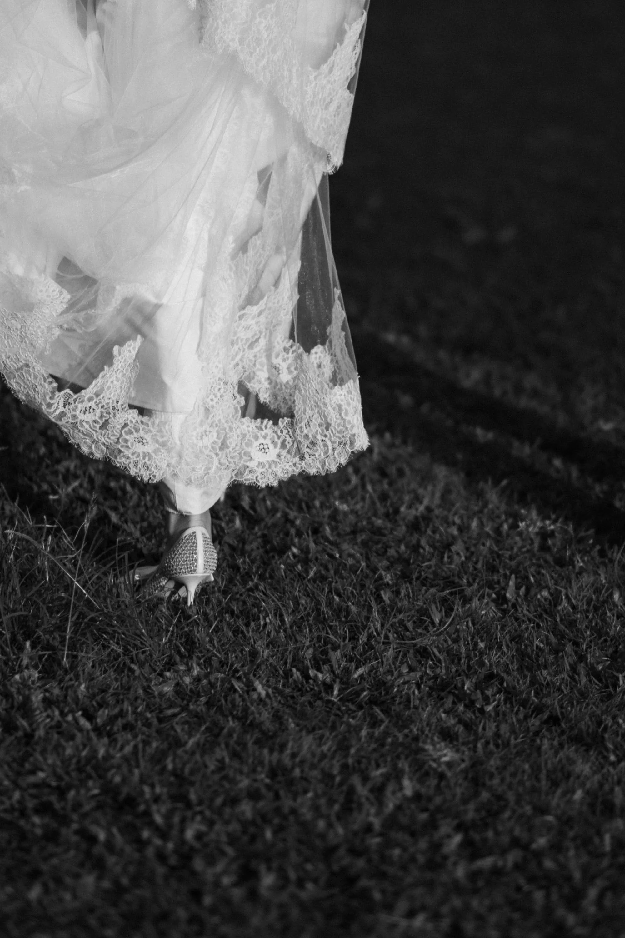 Close-up of the bride’s lace wedding dress and shoes.
