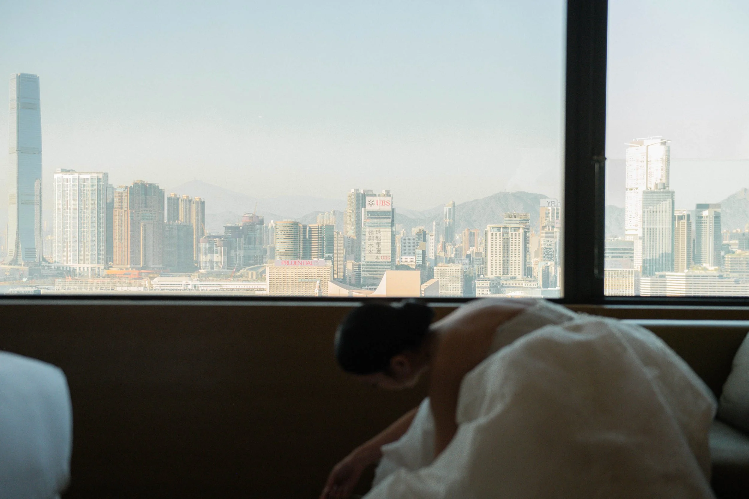 Bride putting on her shoes with Victoria Harbour in the background.