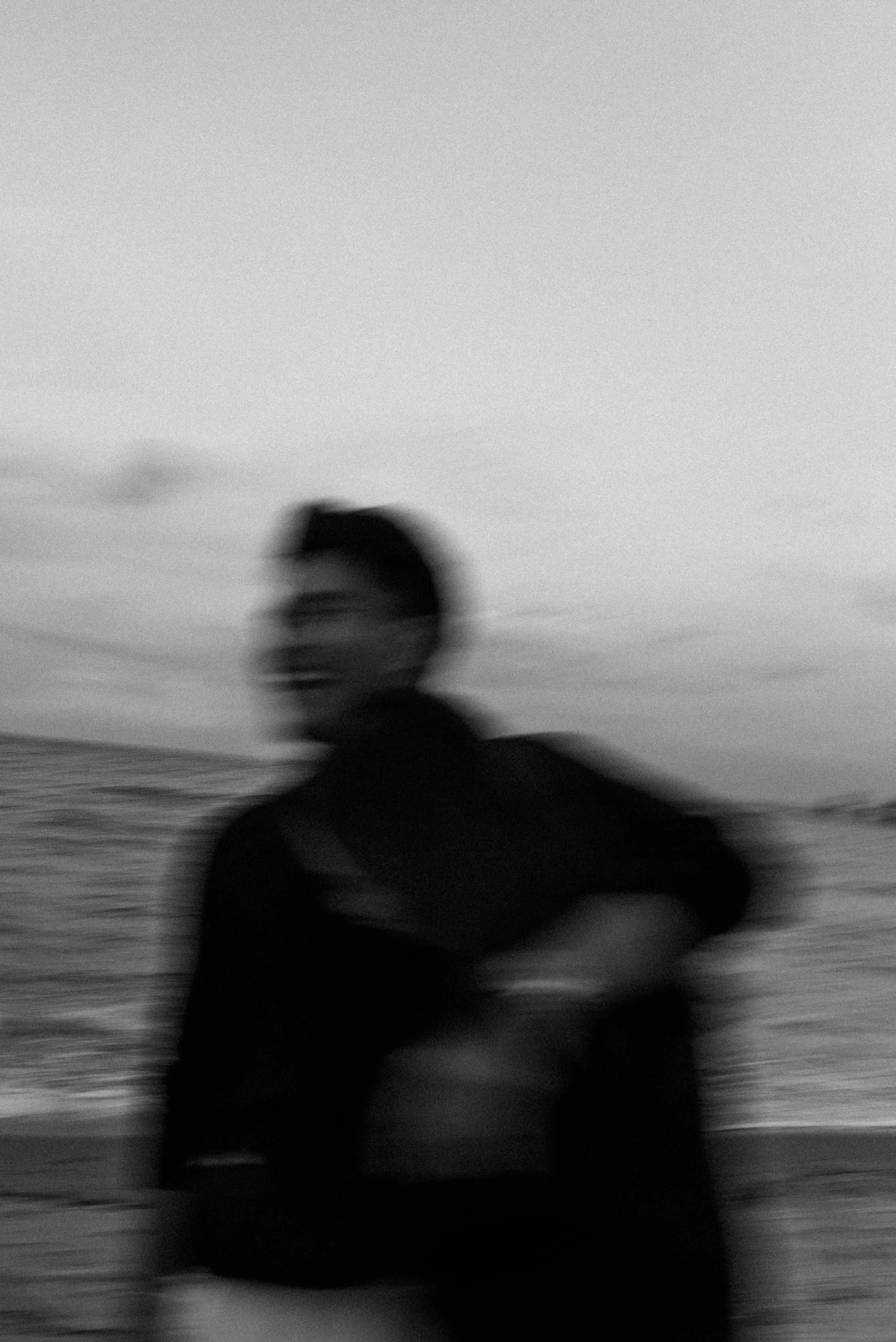 Couple laughing together as they walk along the beach.
