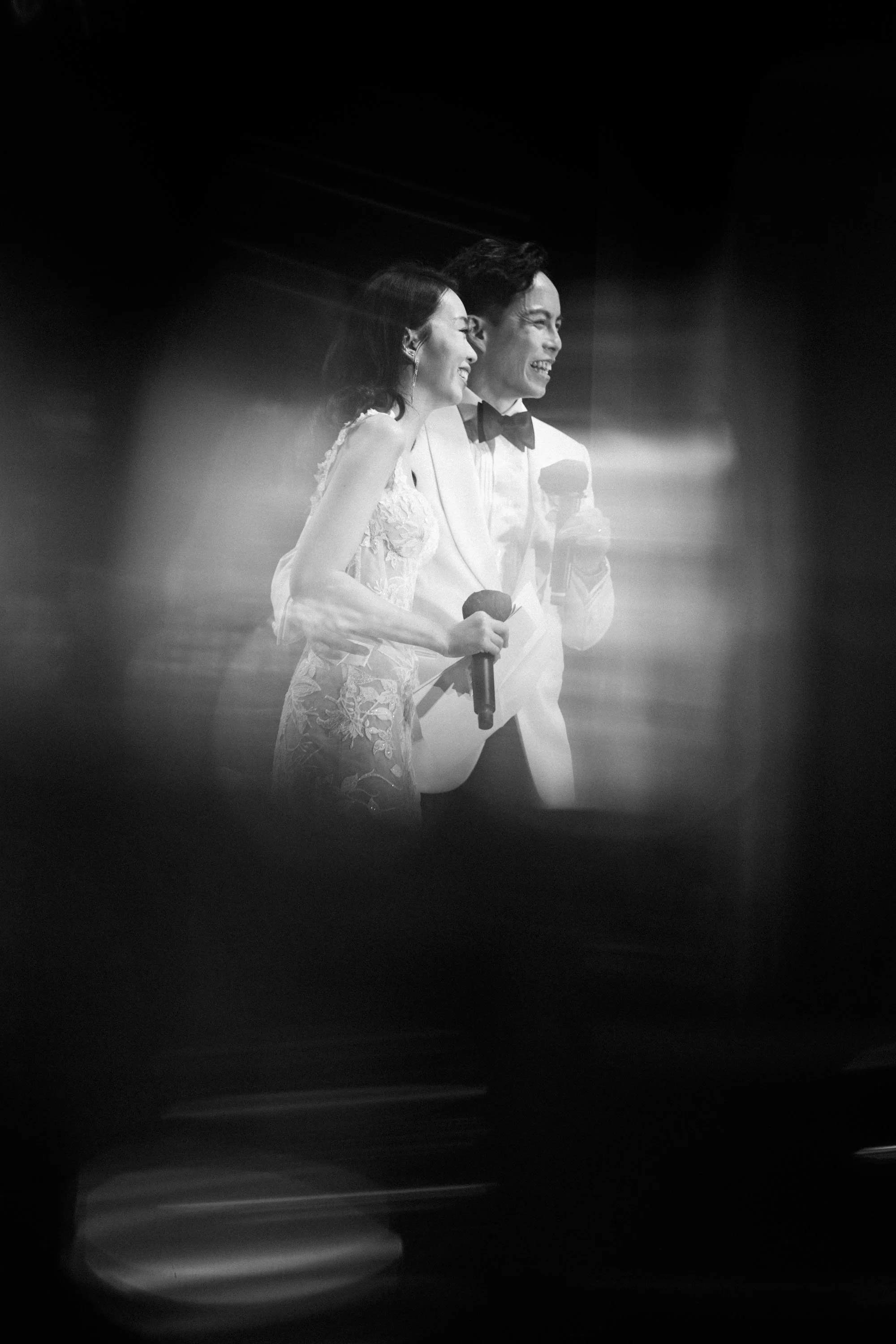 Bride and groom seen through champagne glasses during their thank-you speech.