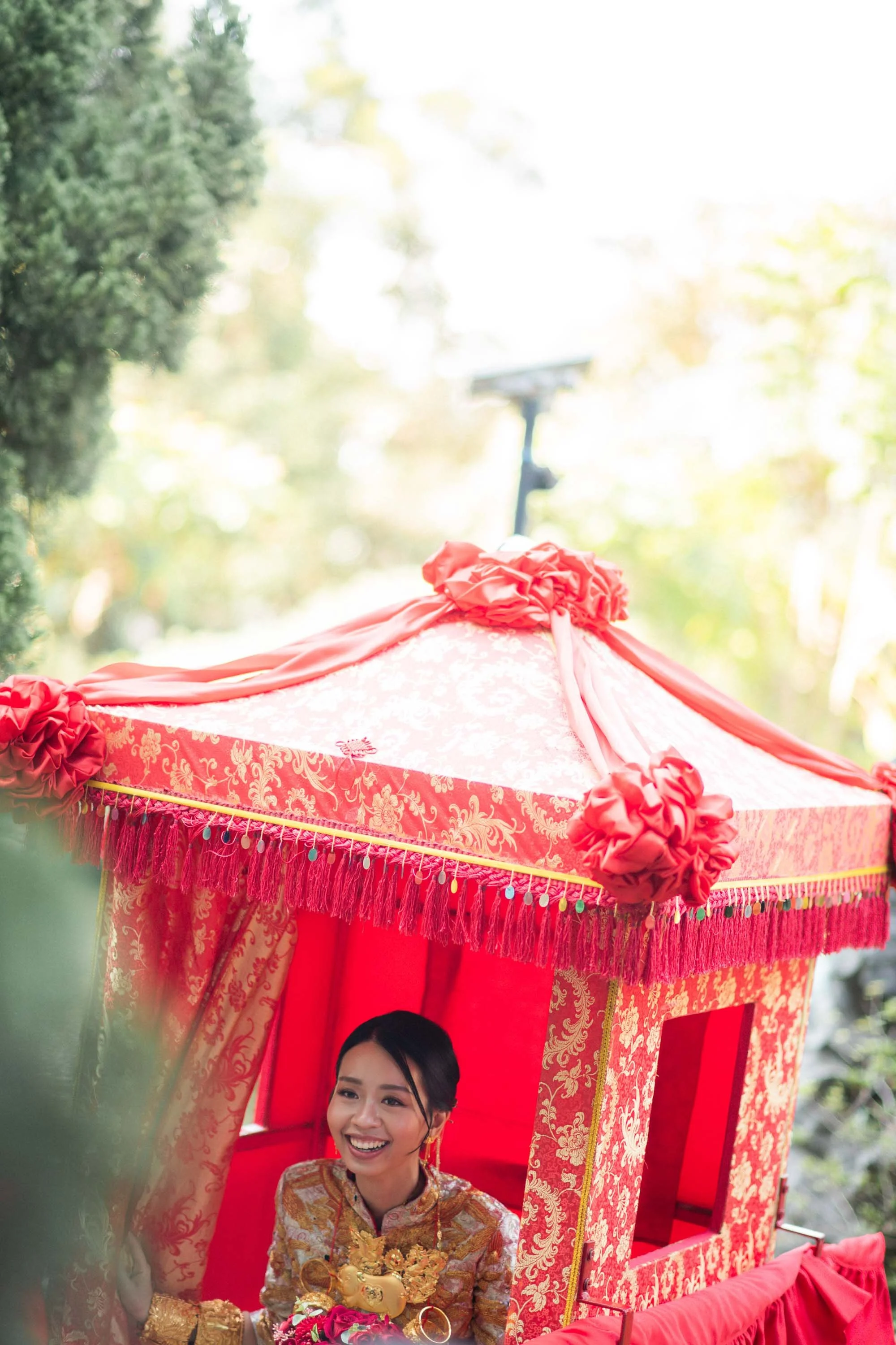 Bride sitting inside the traditional bridal sedan chair.