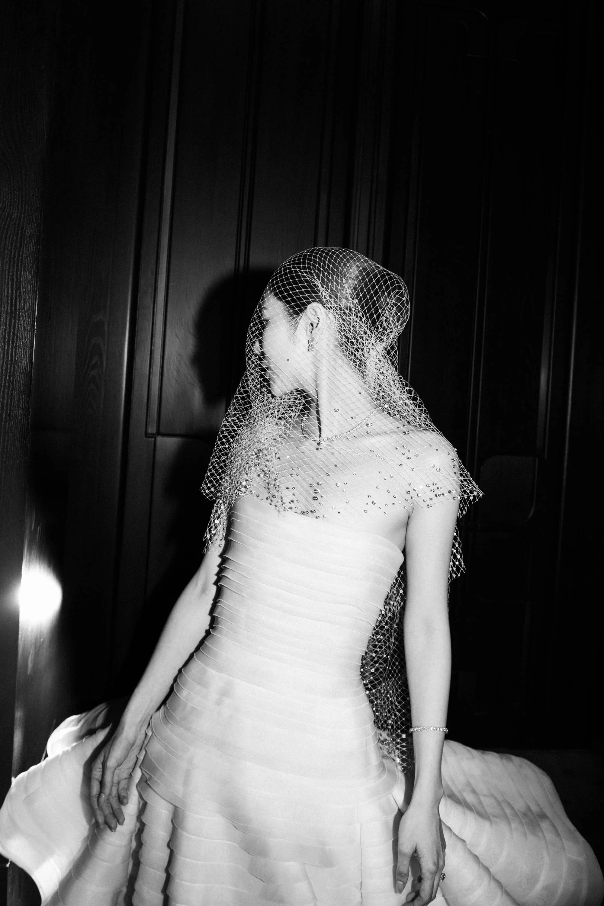 Bride waiting at the ballroom entrance wearing her birdcage veil.