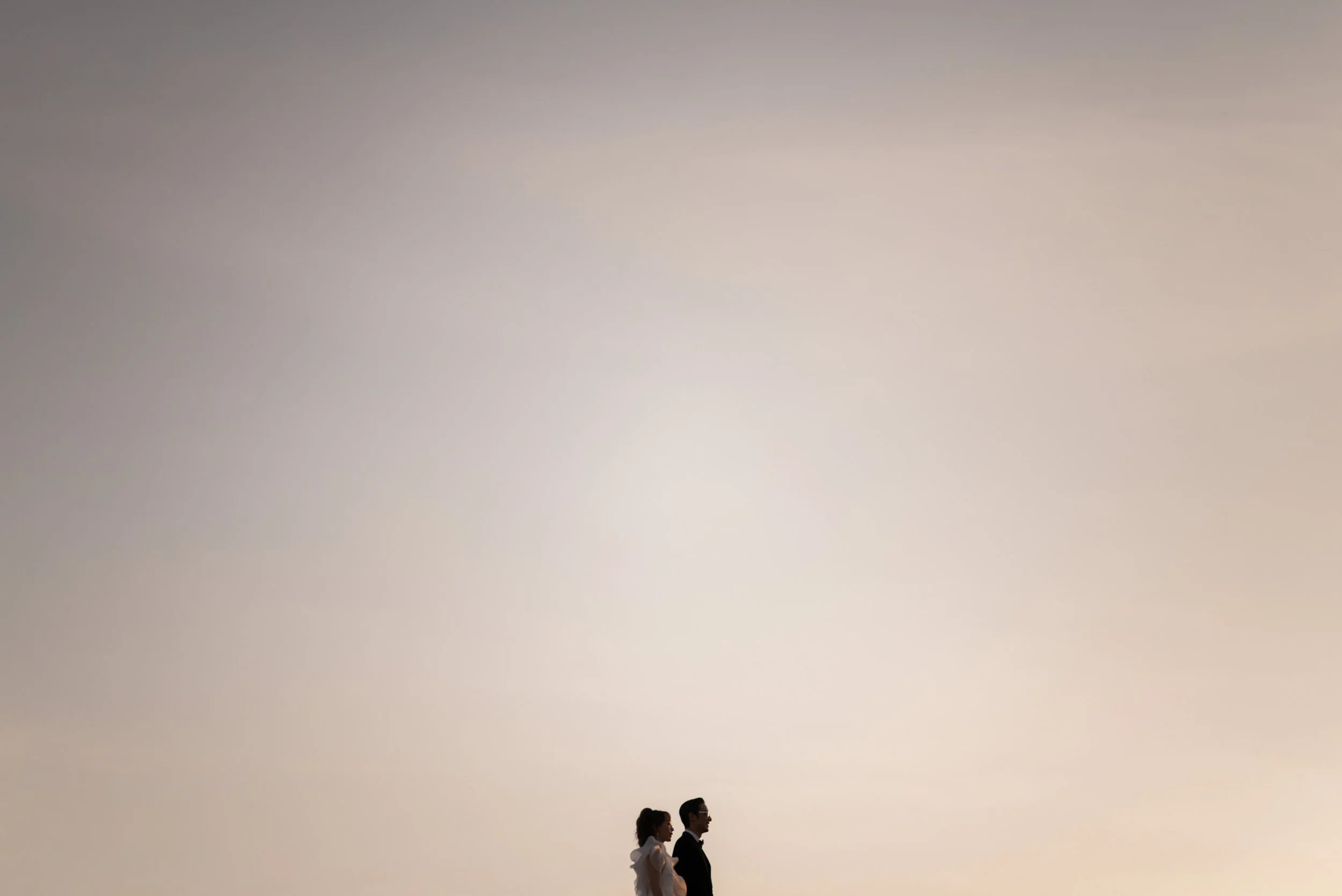 Bride and groom walking together on the rooftop at sunset in Khao Yai.