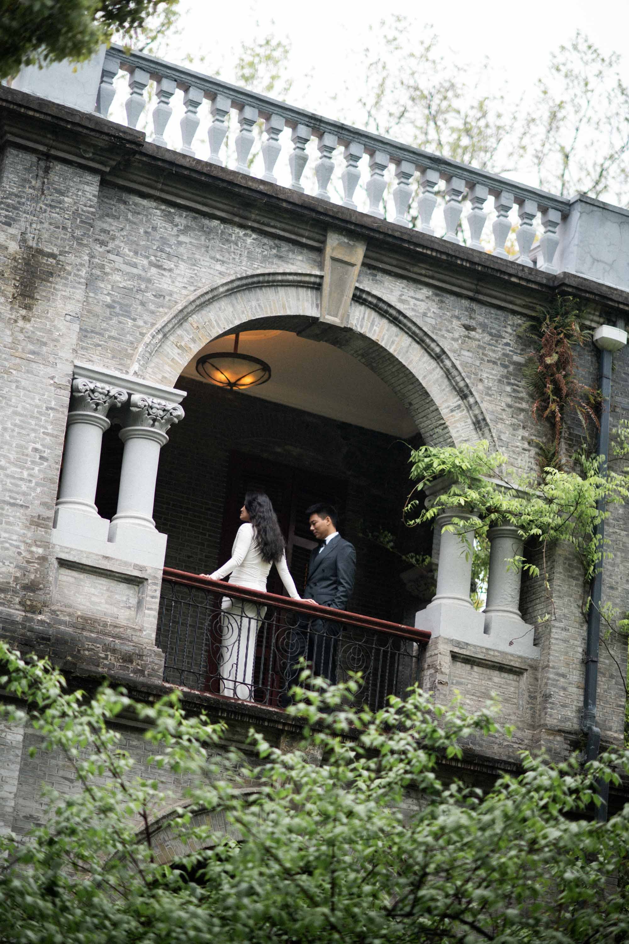 Bride and groom standing together on the balcony.