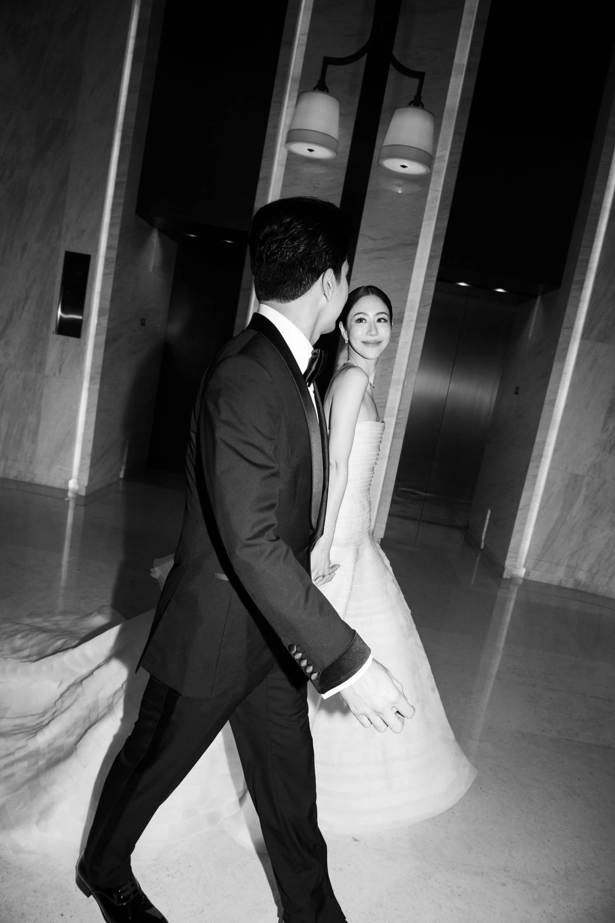 Bride and groom walking together before entering the ballroom.