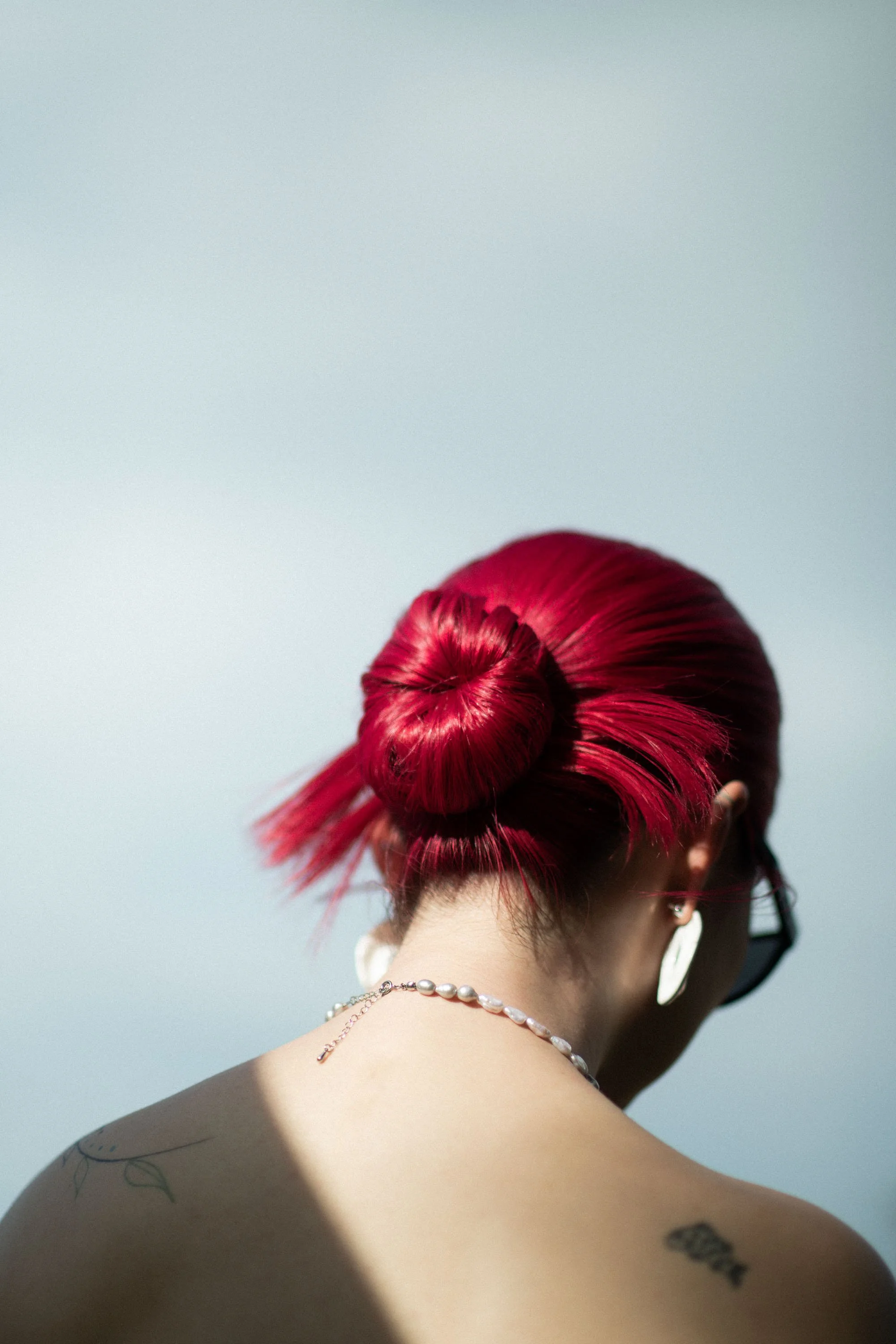 Bride holding her bouquet with her bright red hair catching the light.