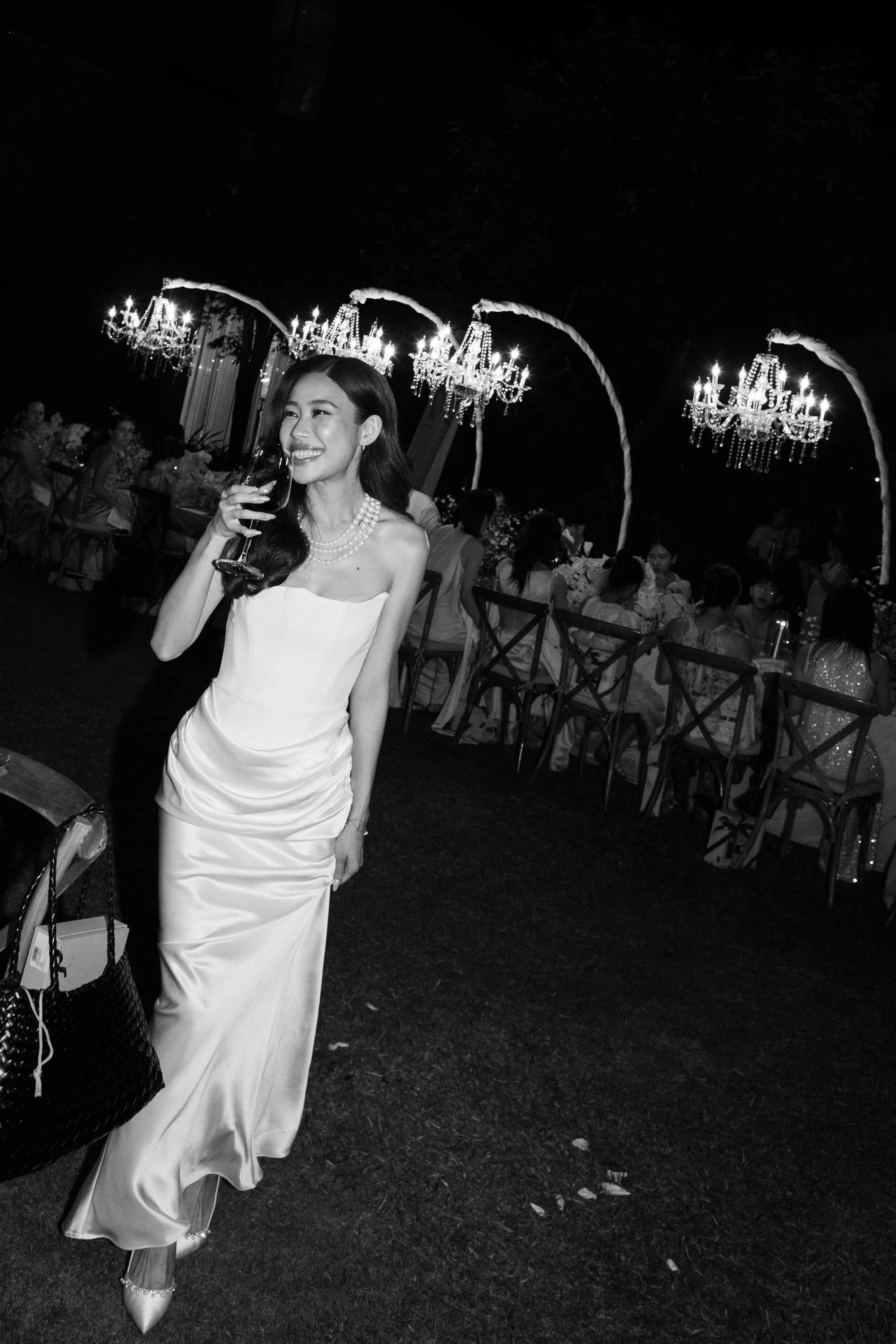 Bride walking through the reception with a cocktail in hand.