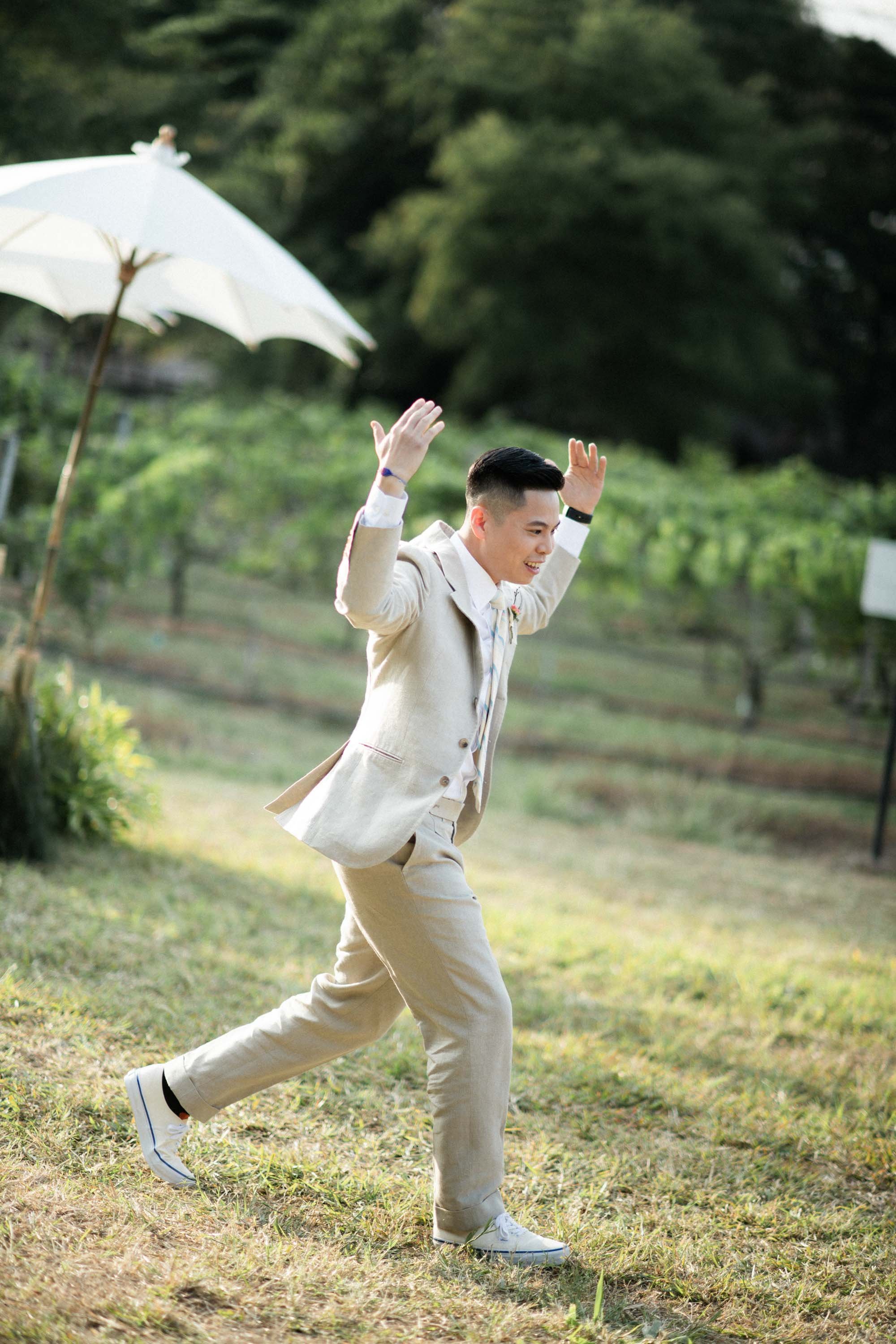 Groom making an energetic entrance to the wedding ceremony.