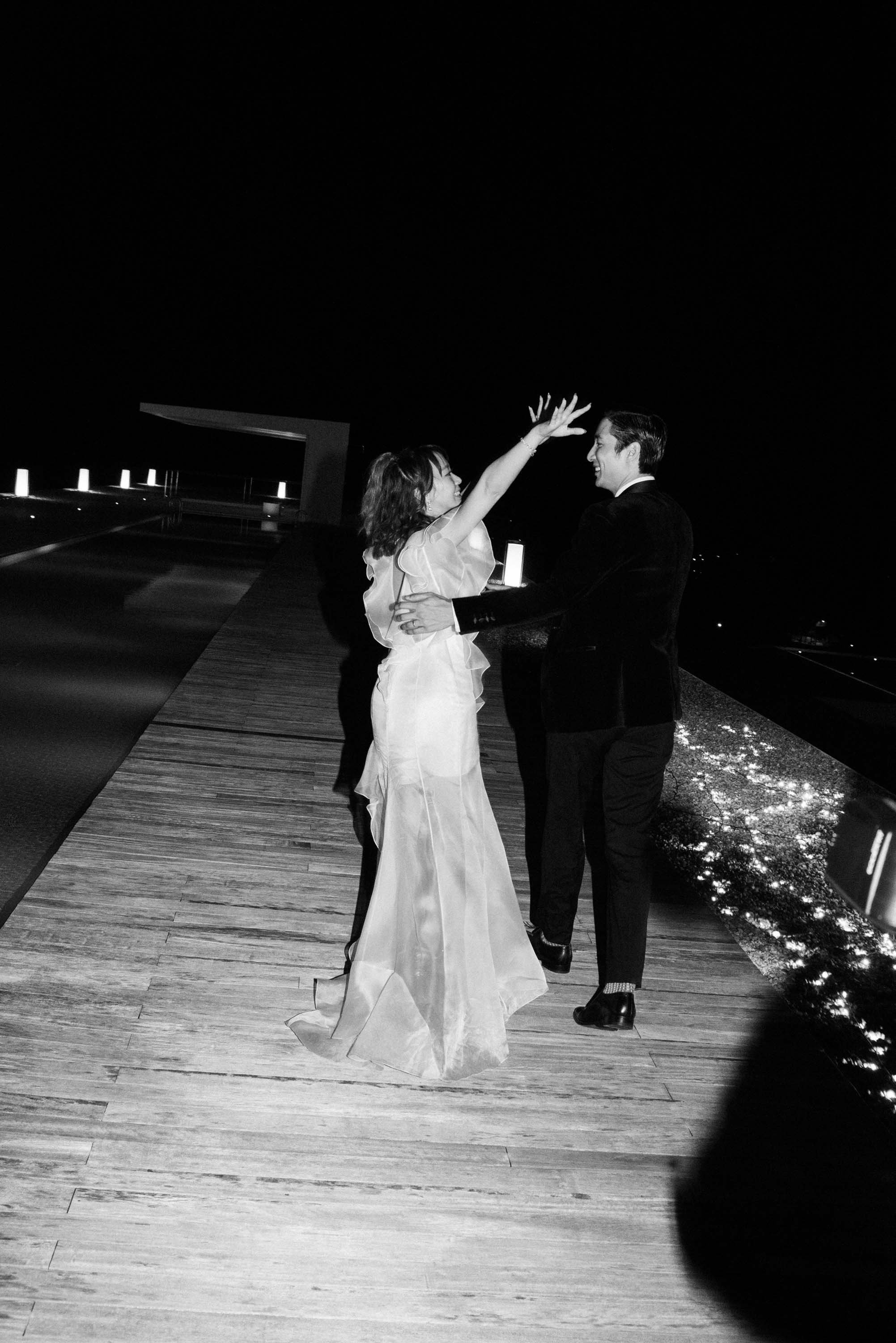 Bride reaching out to embrace the groom during the celebration.