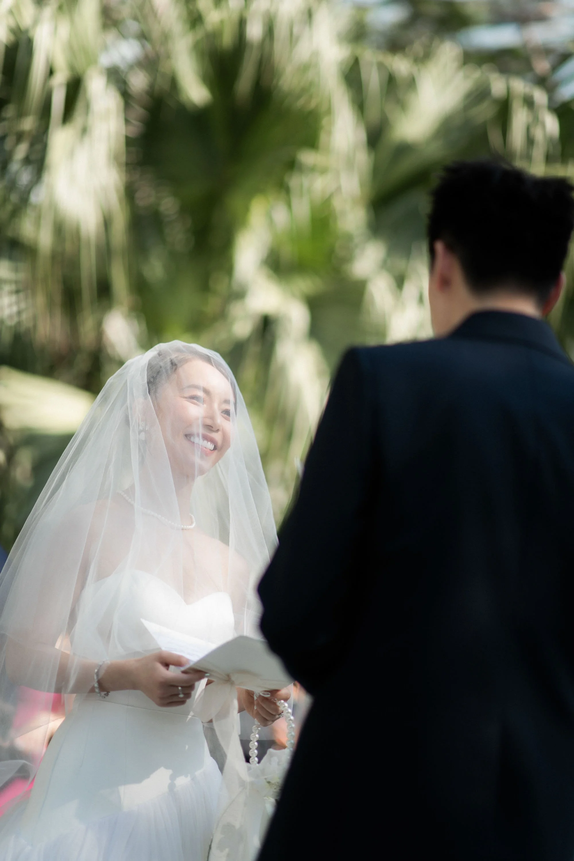 Bride smiling at the groom during the wedding vows.