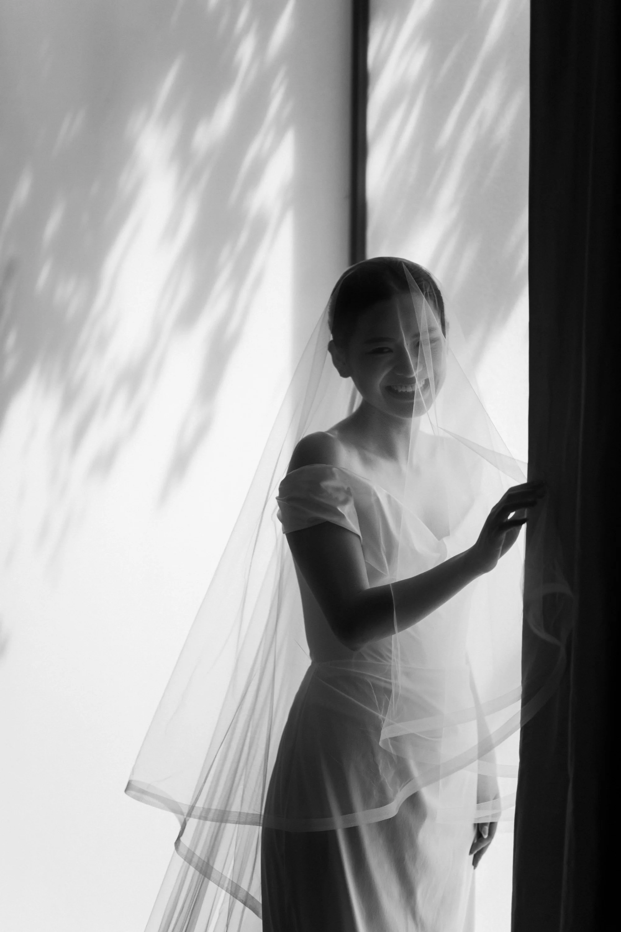 Bride smiling in soft natural light before the ceremony.