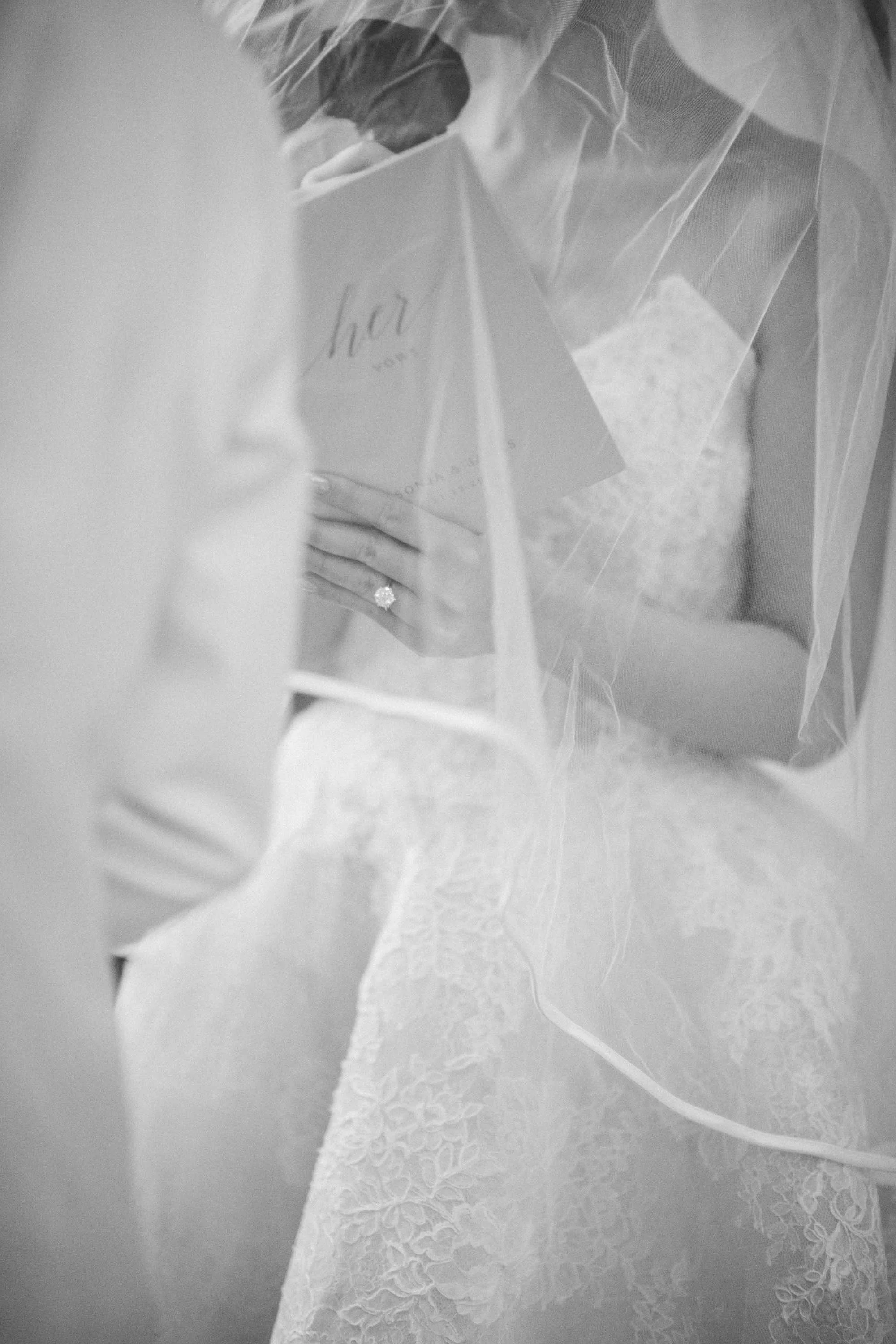 Bride holding the groom’s hand while reading her vows.