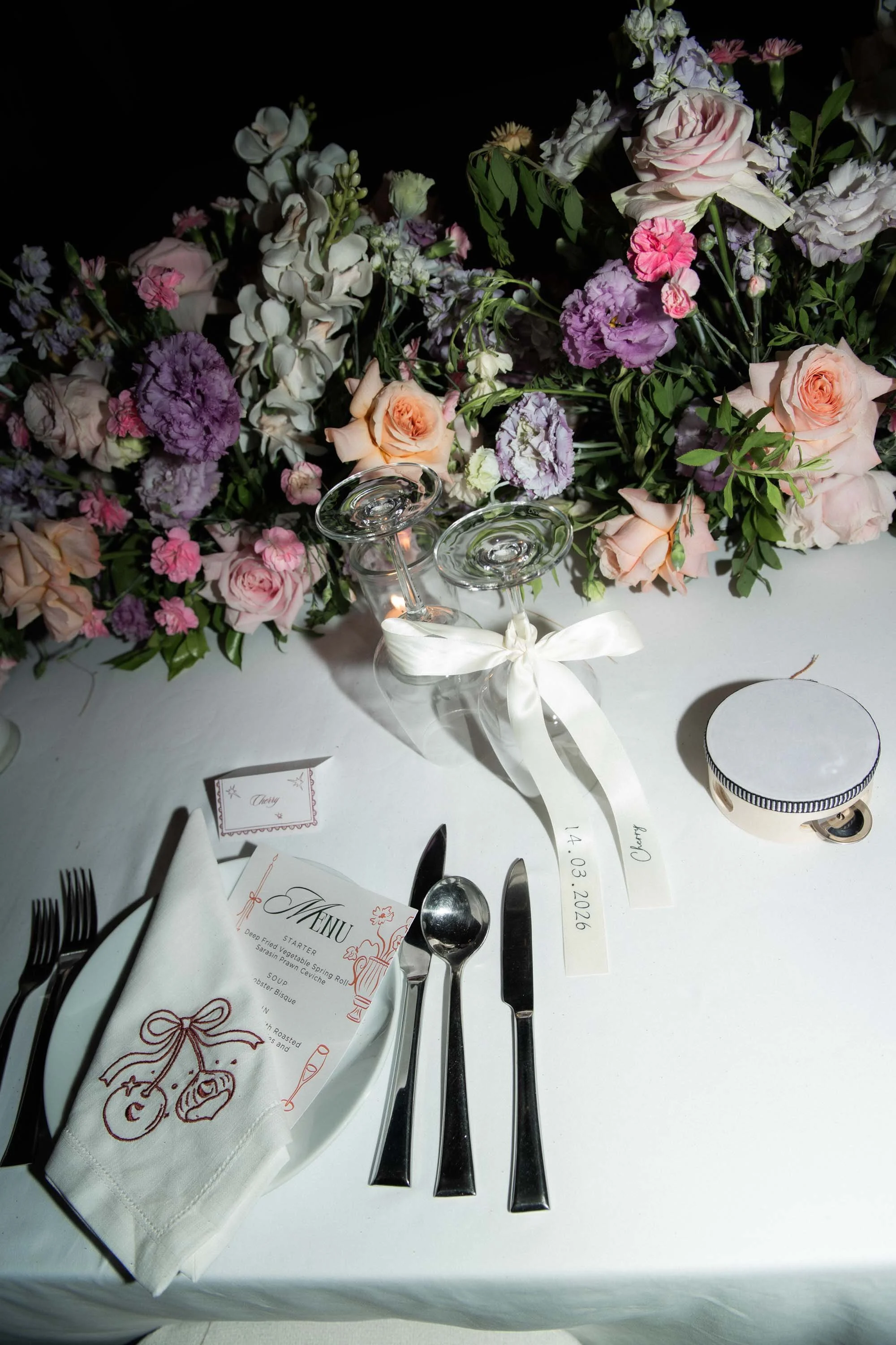 Reception table decorated with flowers and personalized place settings.