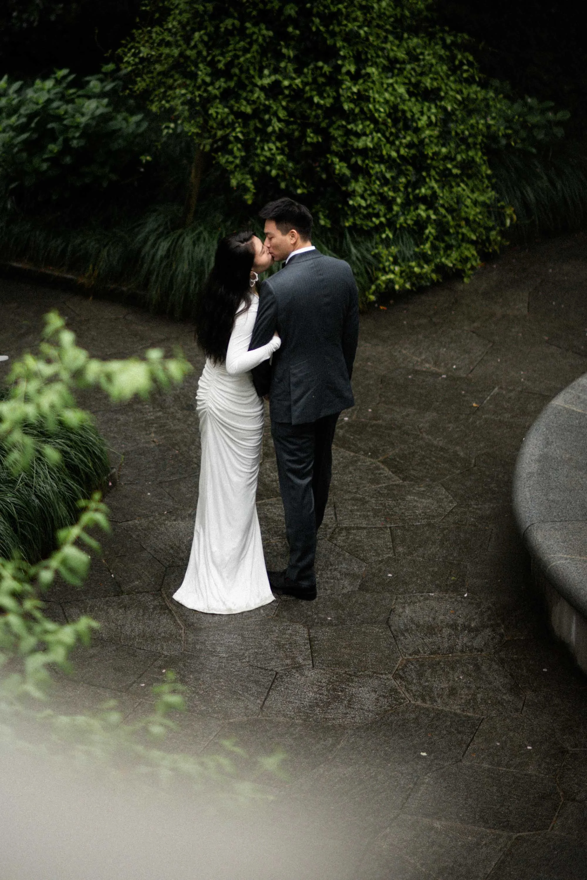 Bride and groom sharing a kiss in the garden.