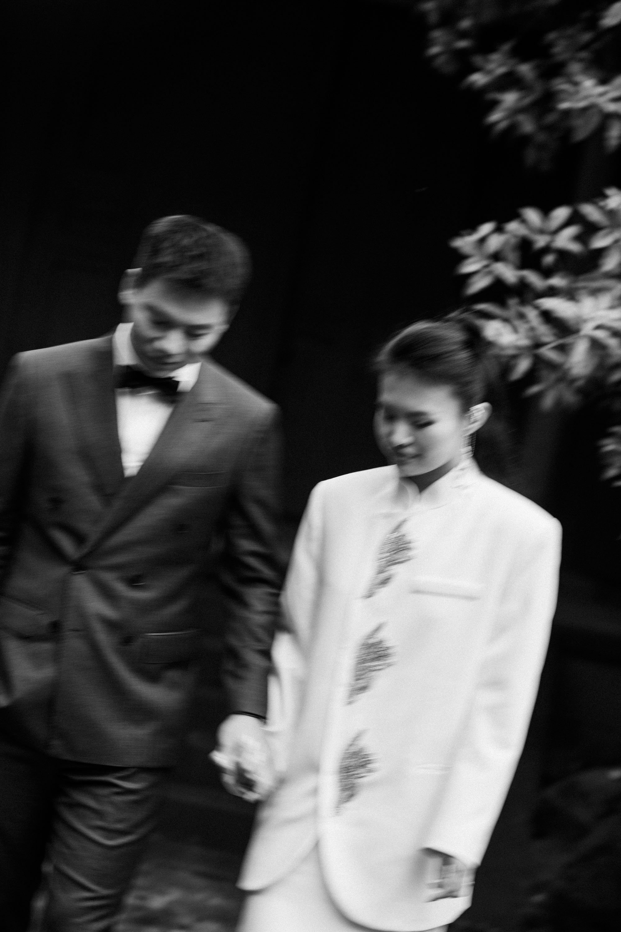 Bride and groom walking together through the garden.