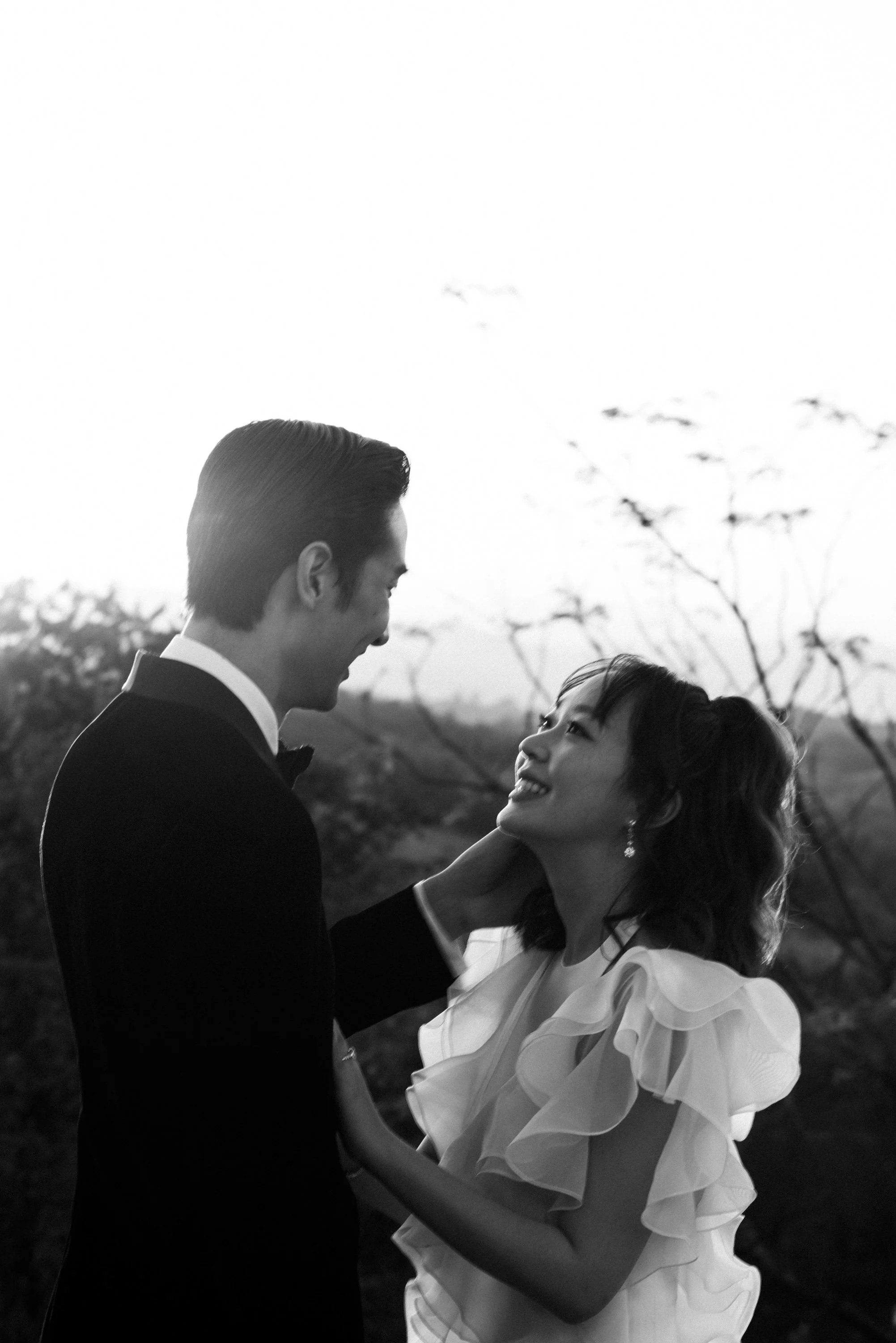 Groom gently holding the bride's face as they look at each other.