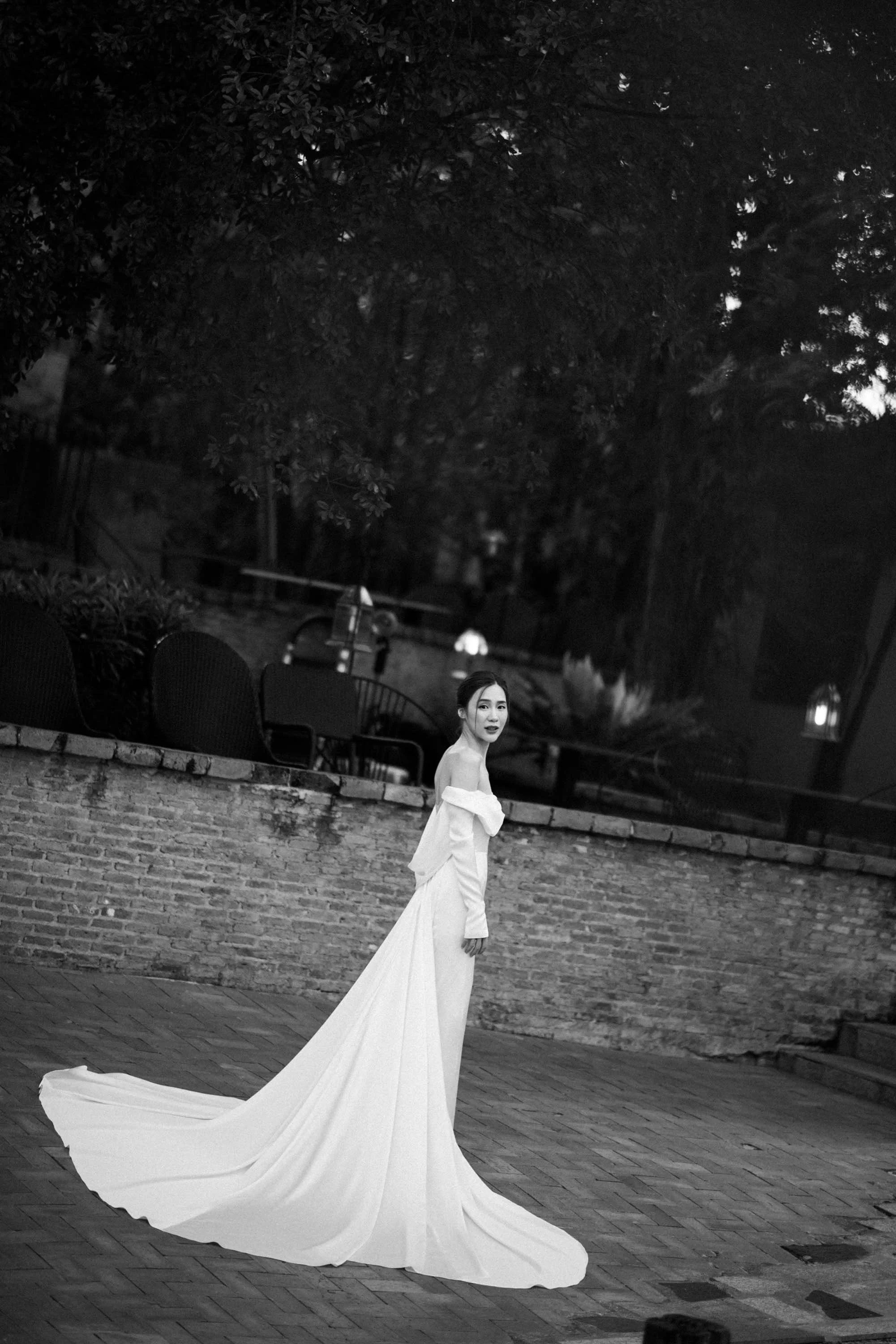 Bride standing alone in an elegant simple wedding dress.