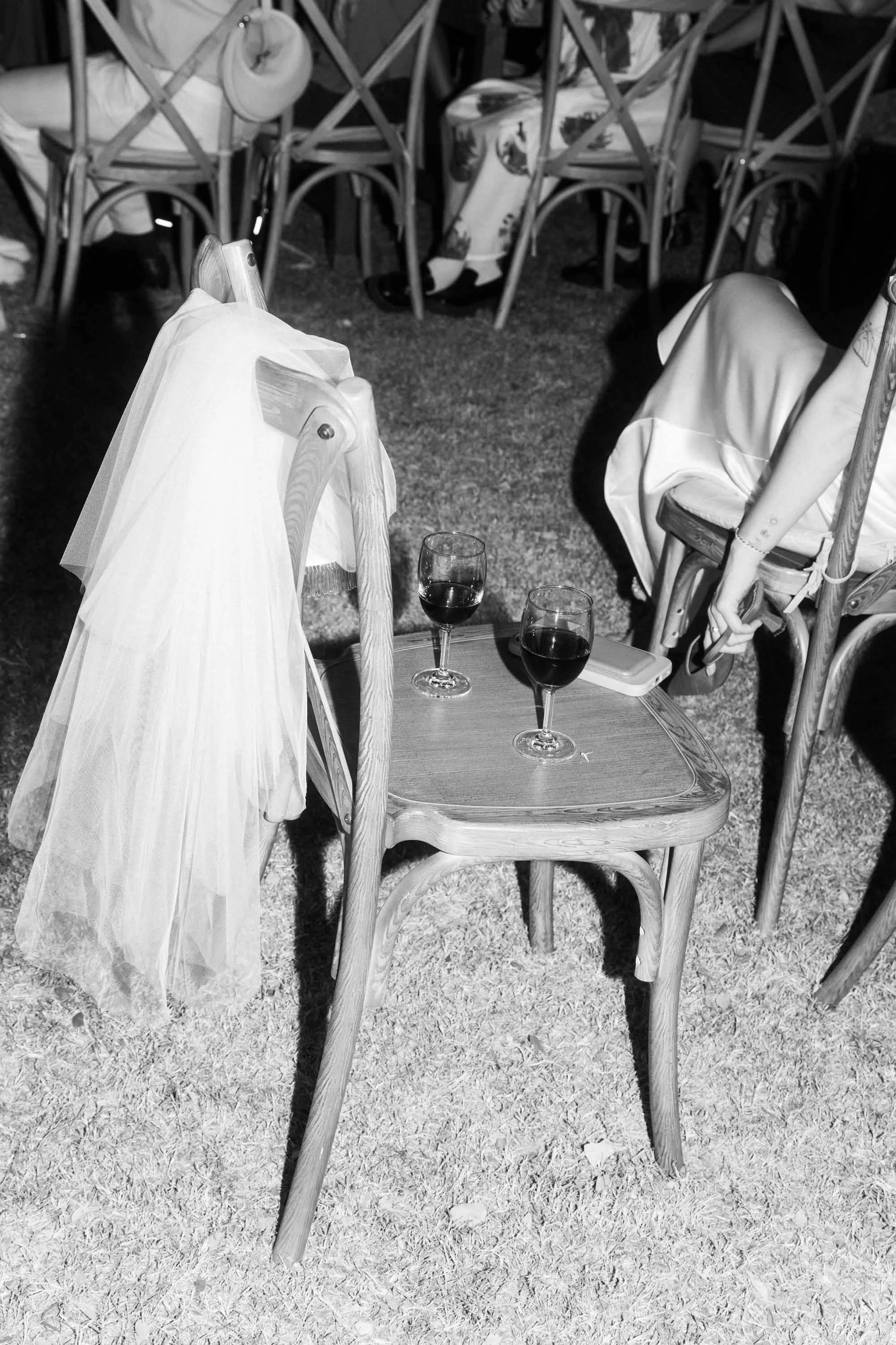Wine glasses resting on chairs during a wedding game at the evening reception.