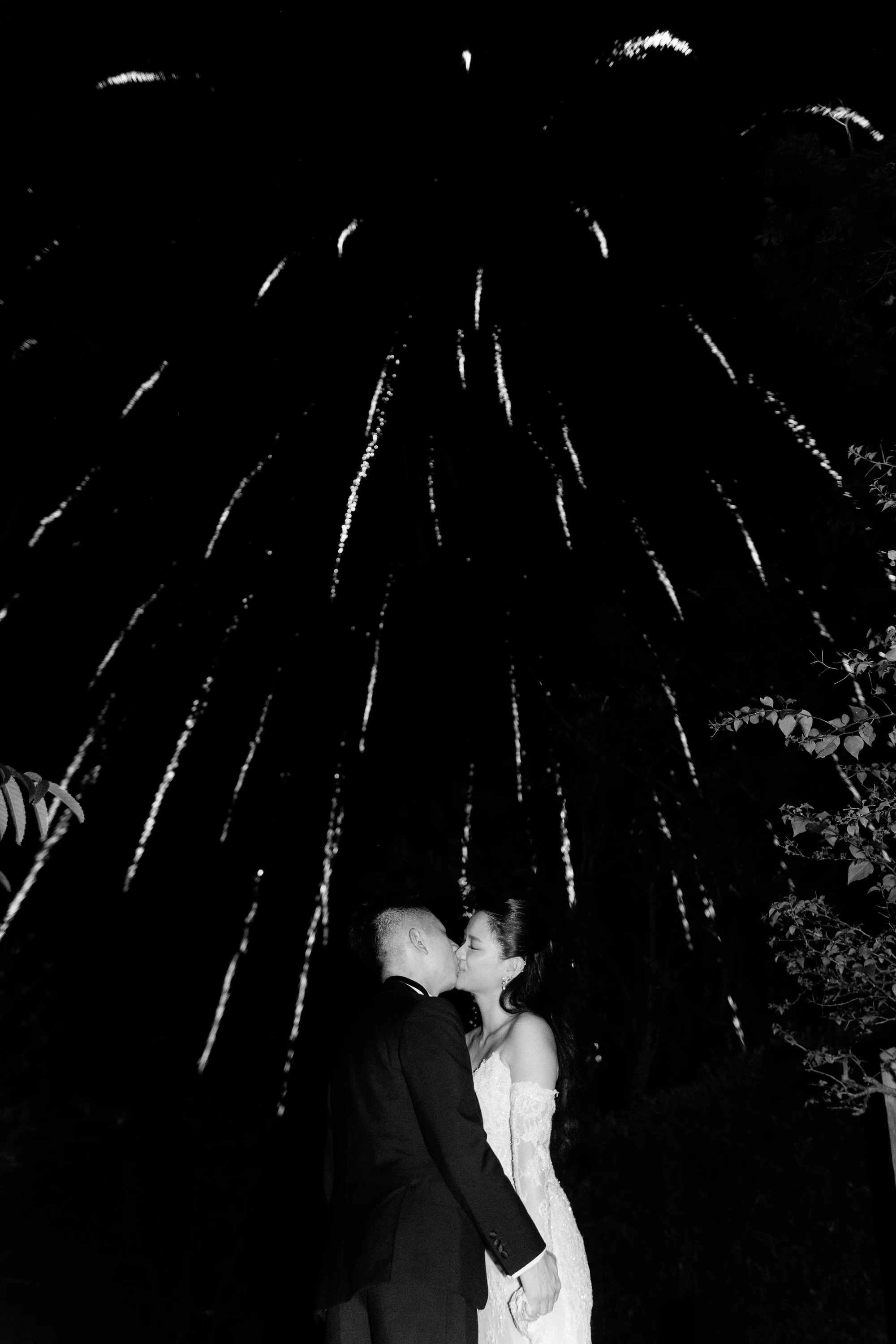Bride and groom sharing a kiss during the fireworks.