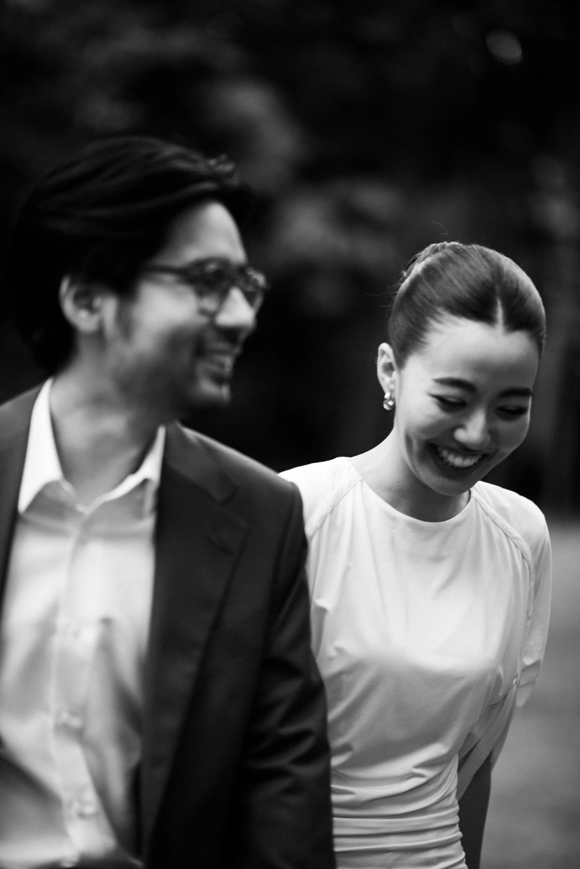 Couple walking together through the garden, smiling and laughing.