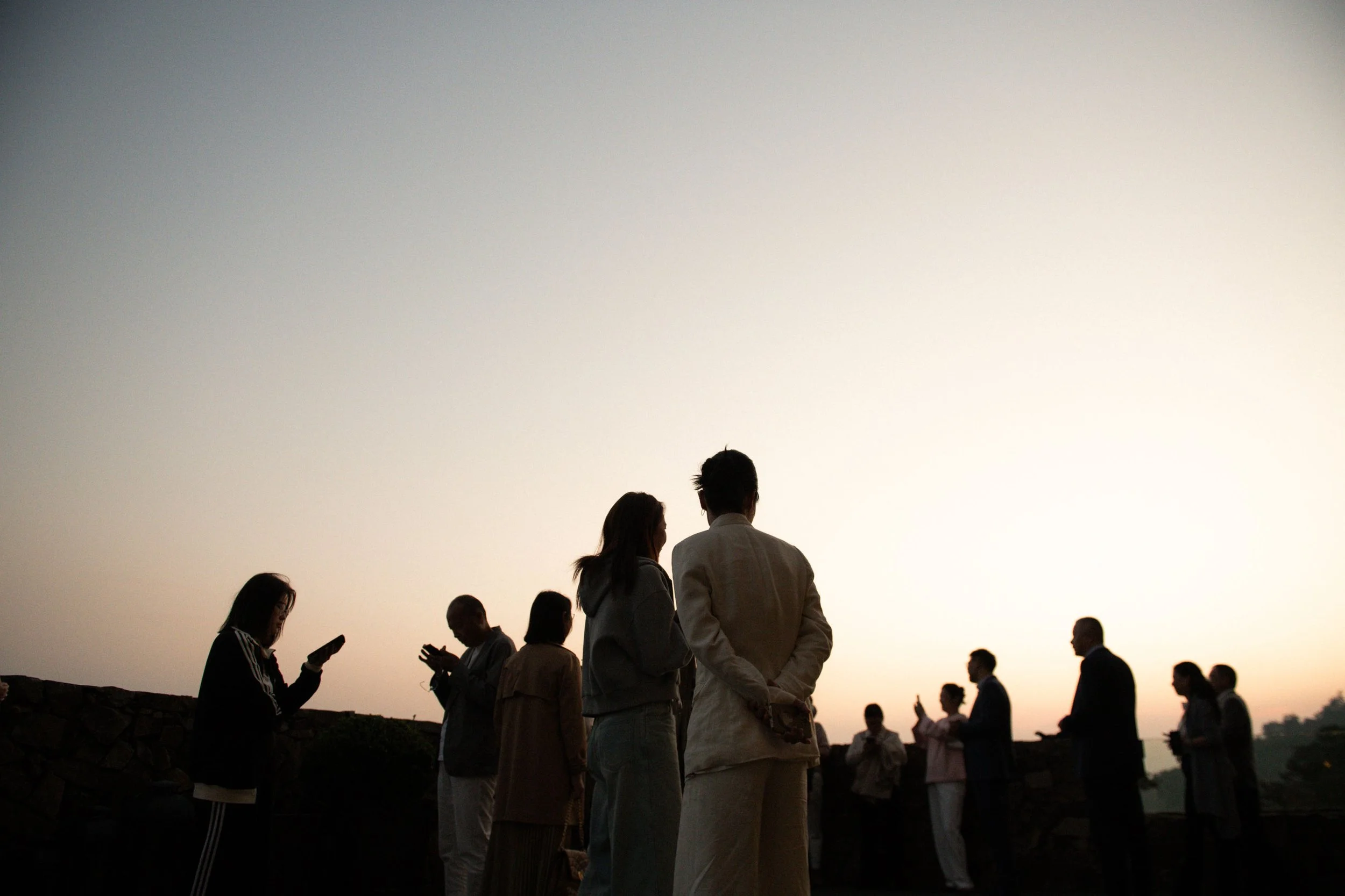 Guests enjoying the sunset during the wedding celebration.