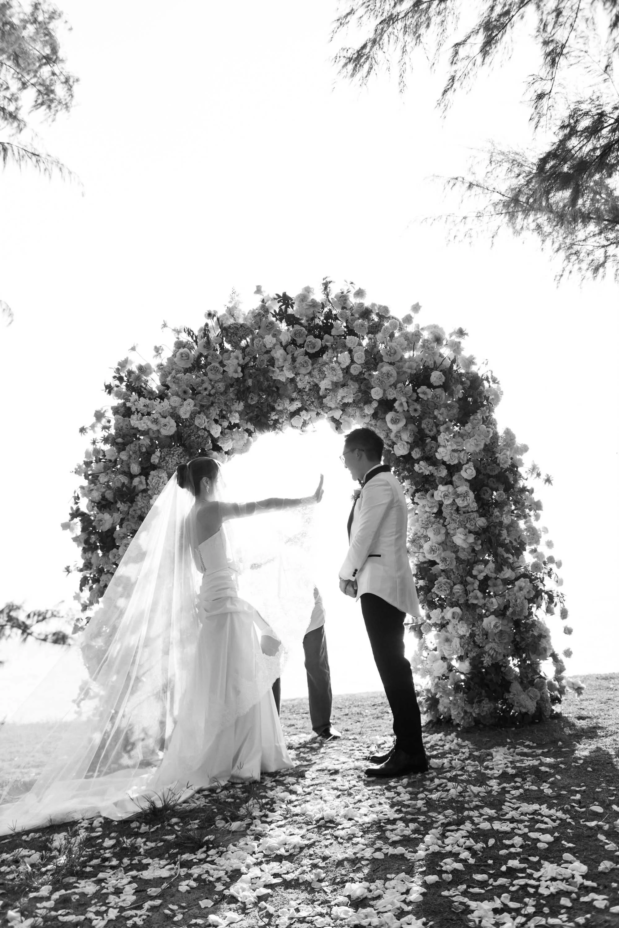 Bride reaching for the groom’s hand during the ring exchange.