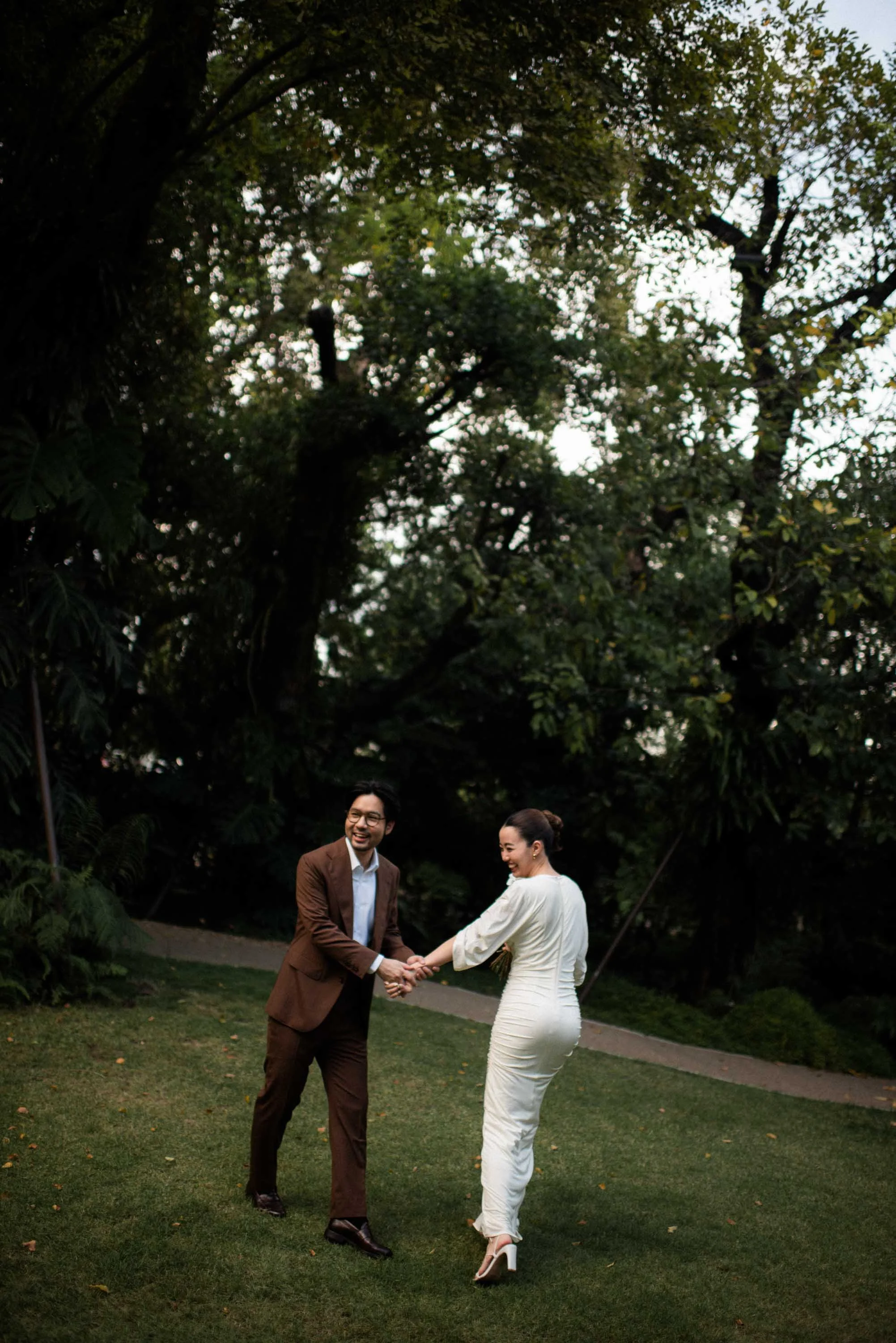 Couple holding hands and laughing as they turn toward the camera.