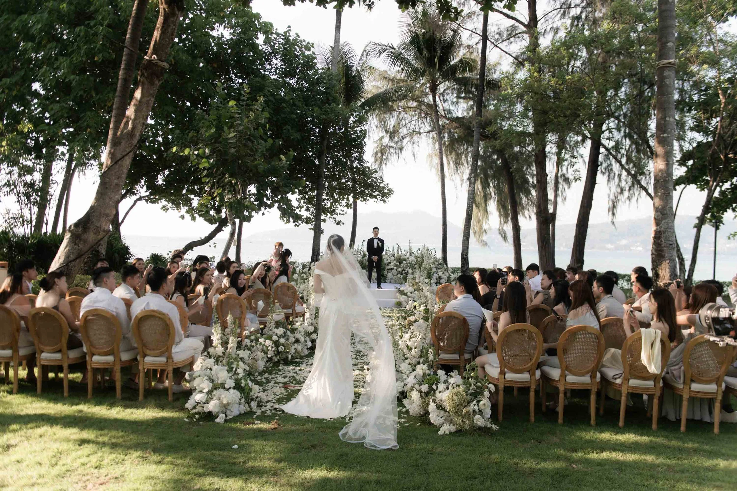 Bride walking down the aisle as guests turn to welcome her.