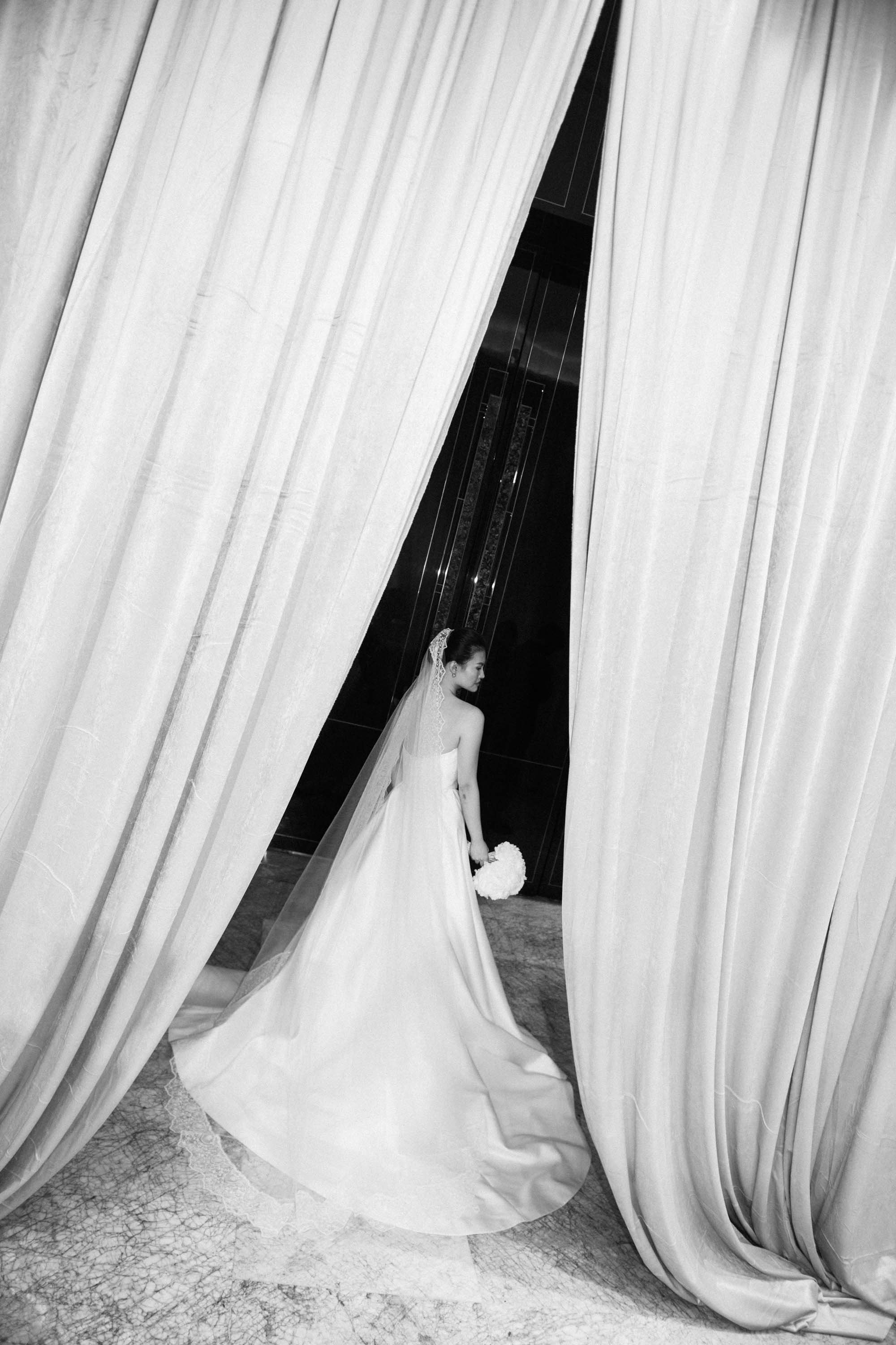 Bride waiting behind the curtain before the reception entrance.