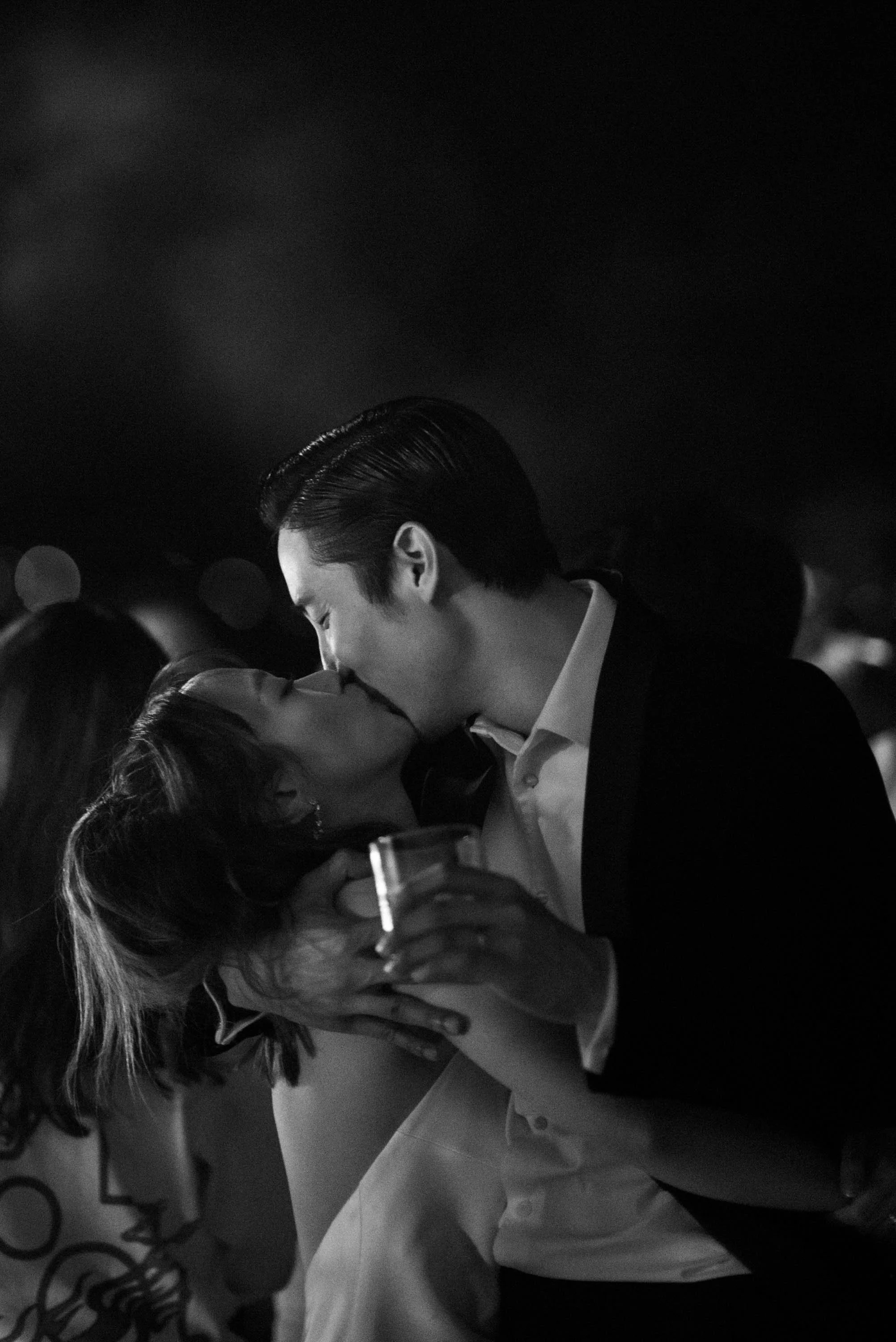 Bride and groom kissing during the party at night.