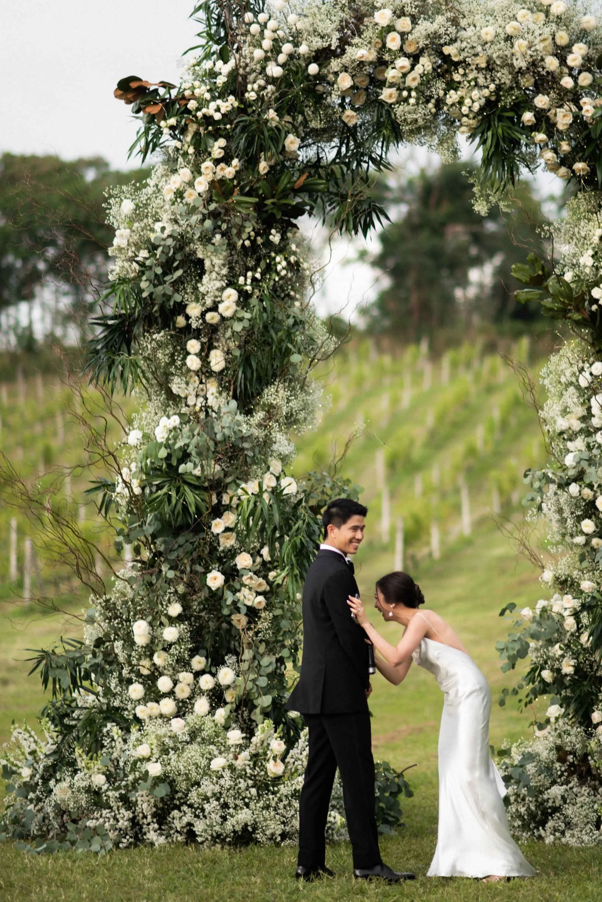 Bride laughing and holding the groom's arm after sharing her vows.