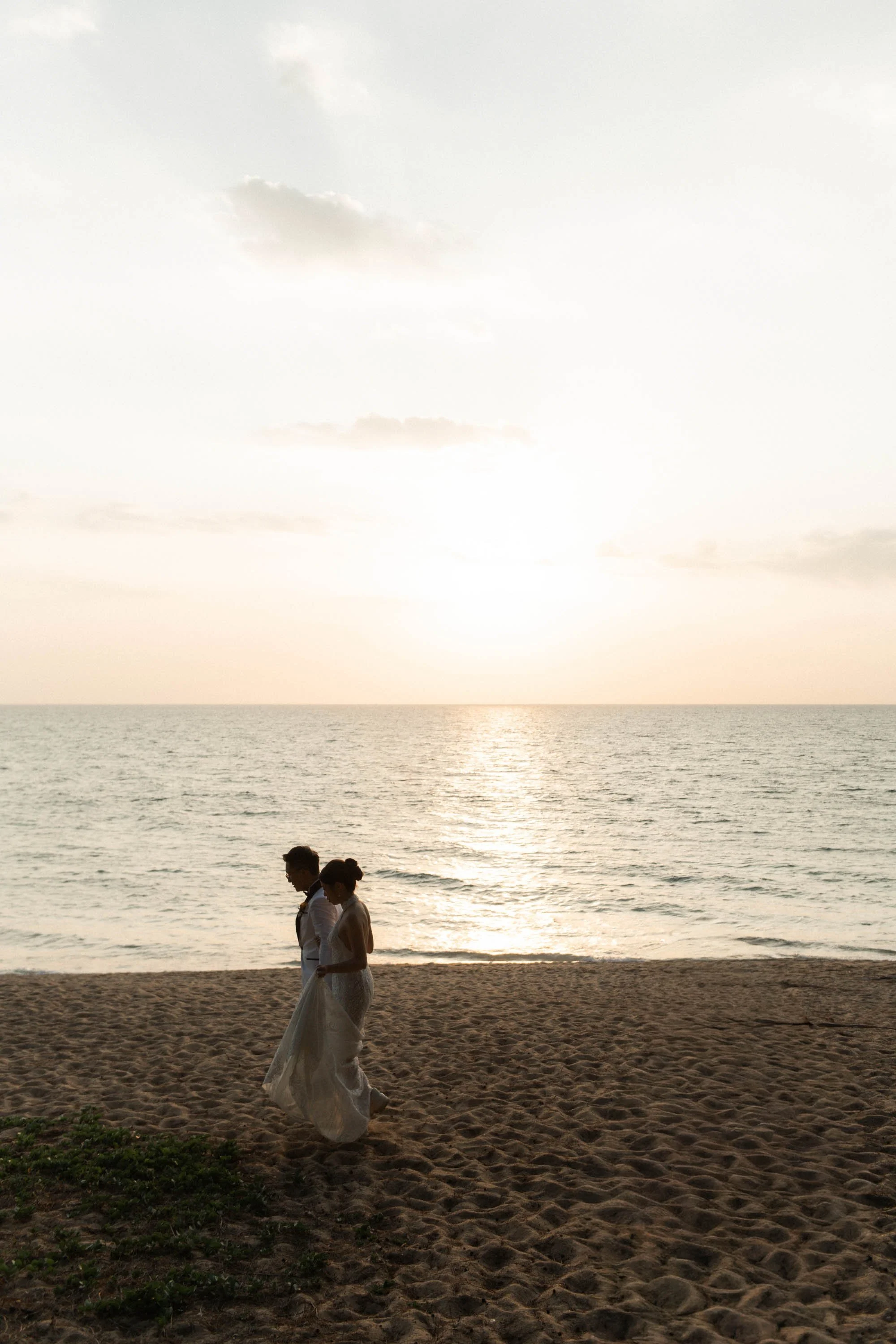 Bride and groom during a portrait session on the beach before sunset.