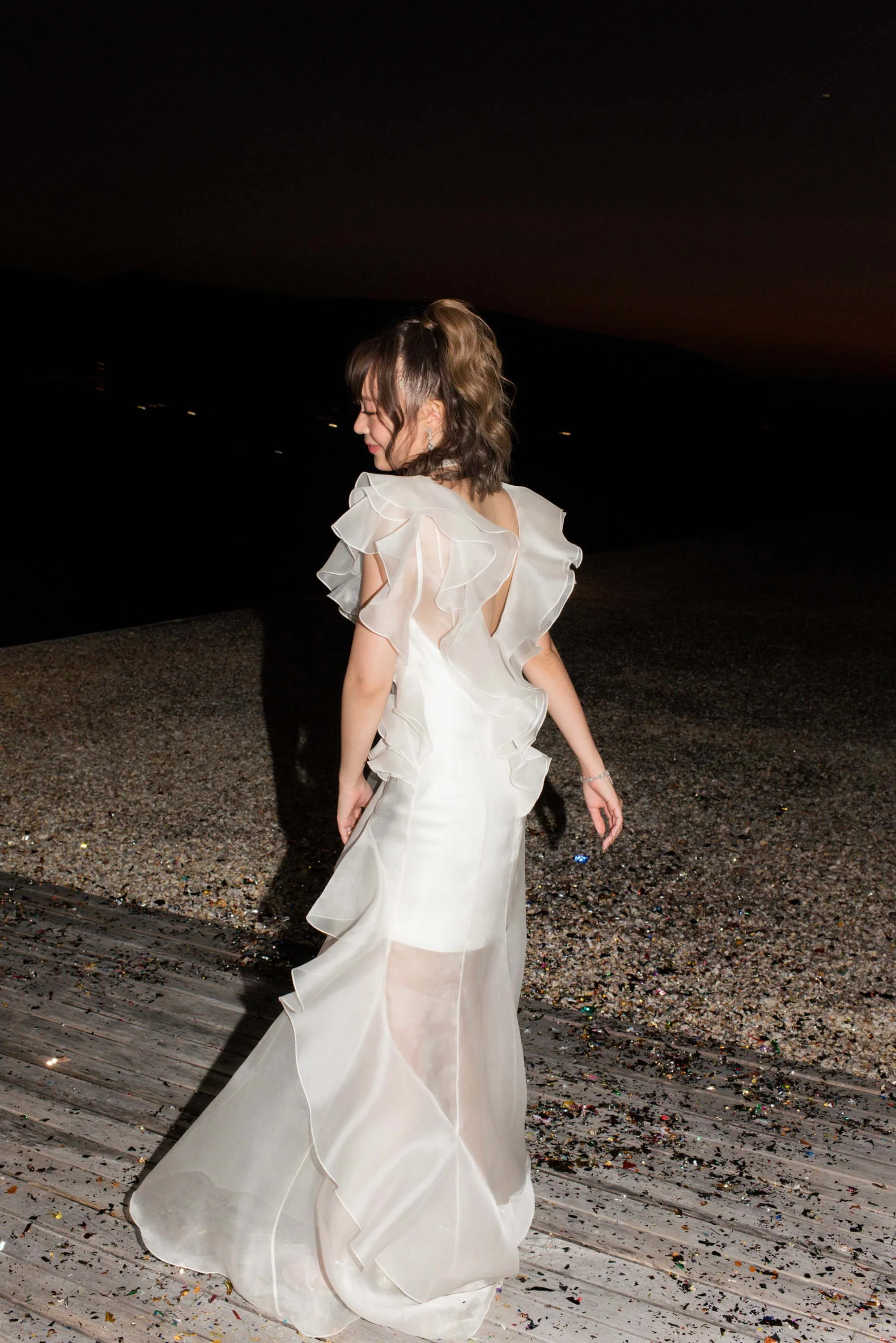 Bride walking toward the dinner table during the evening.