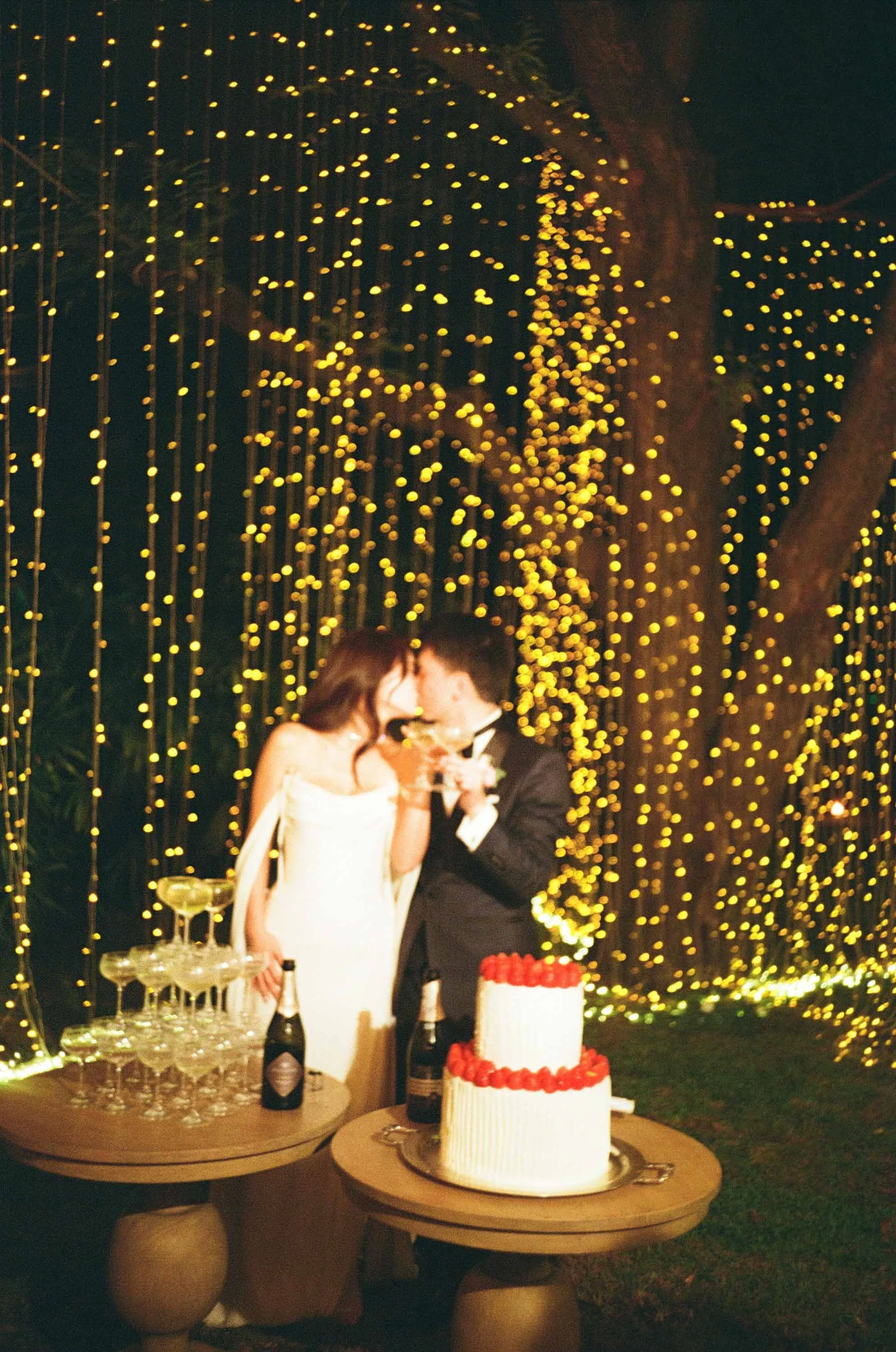 Bride and groom sharing a kiss after cutting their wedding cake.