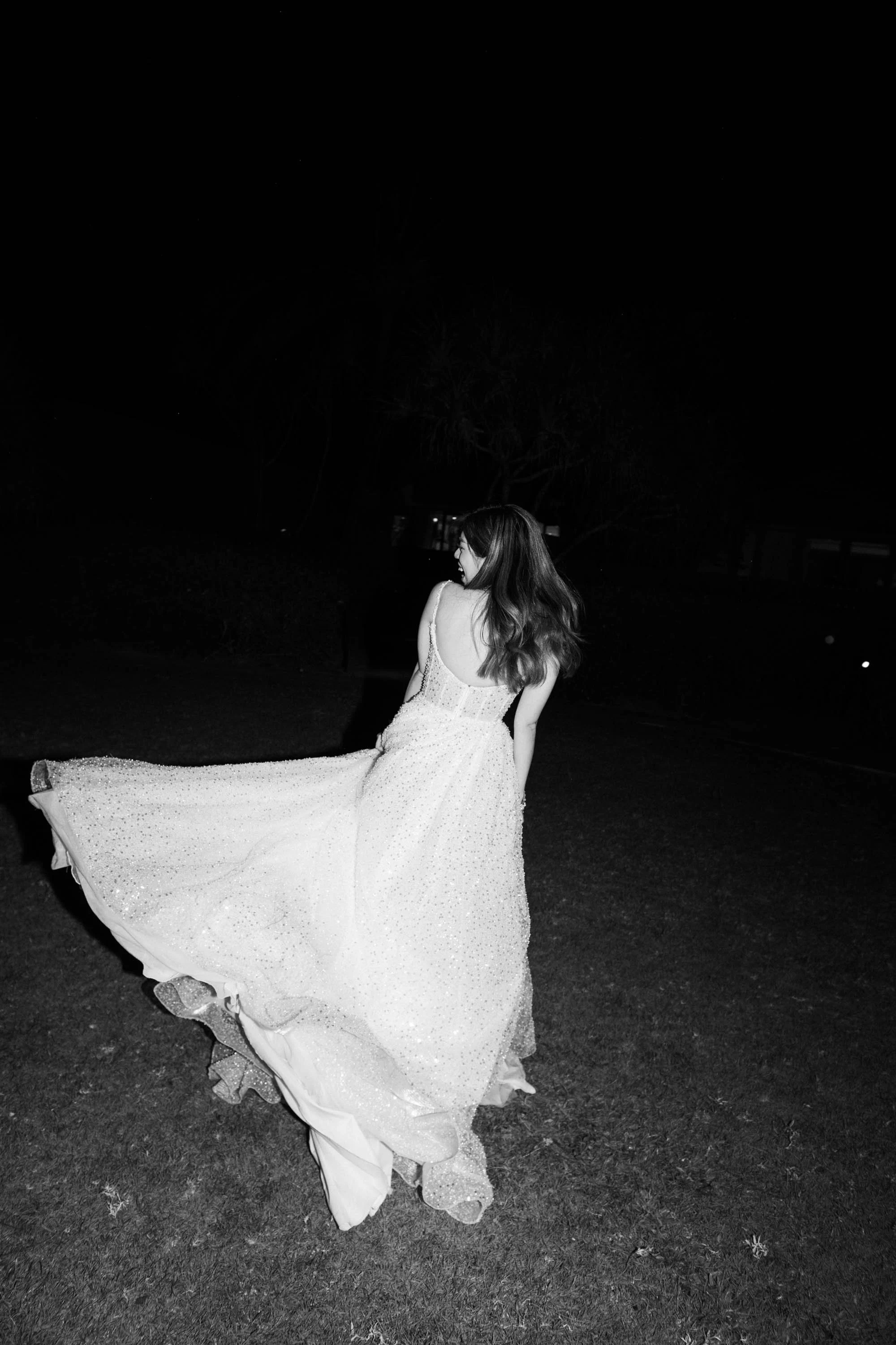 Bride twirling her wedding dress during the evening celebration.
