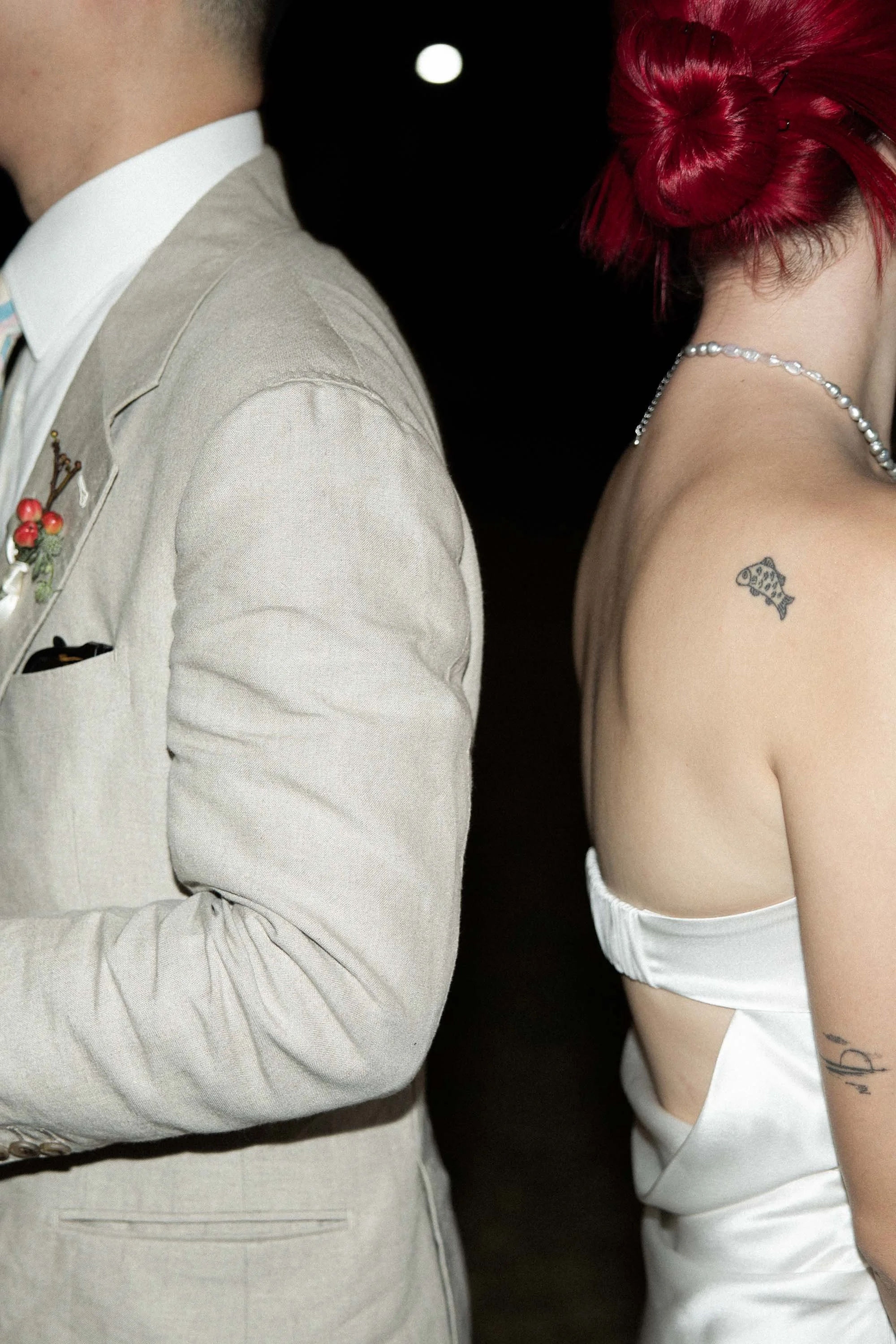 Side profile of the bride and groom showing the groom’s suit and the bride’s red hair.