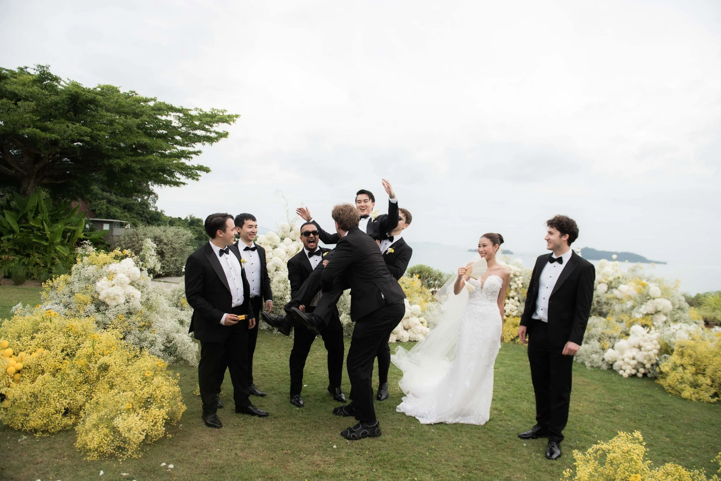 Groom being lifted by his friends during the group photos.