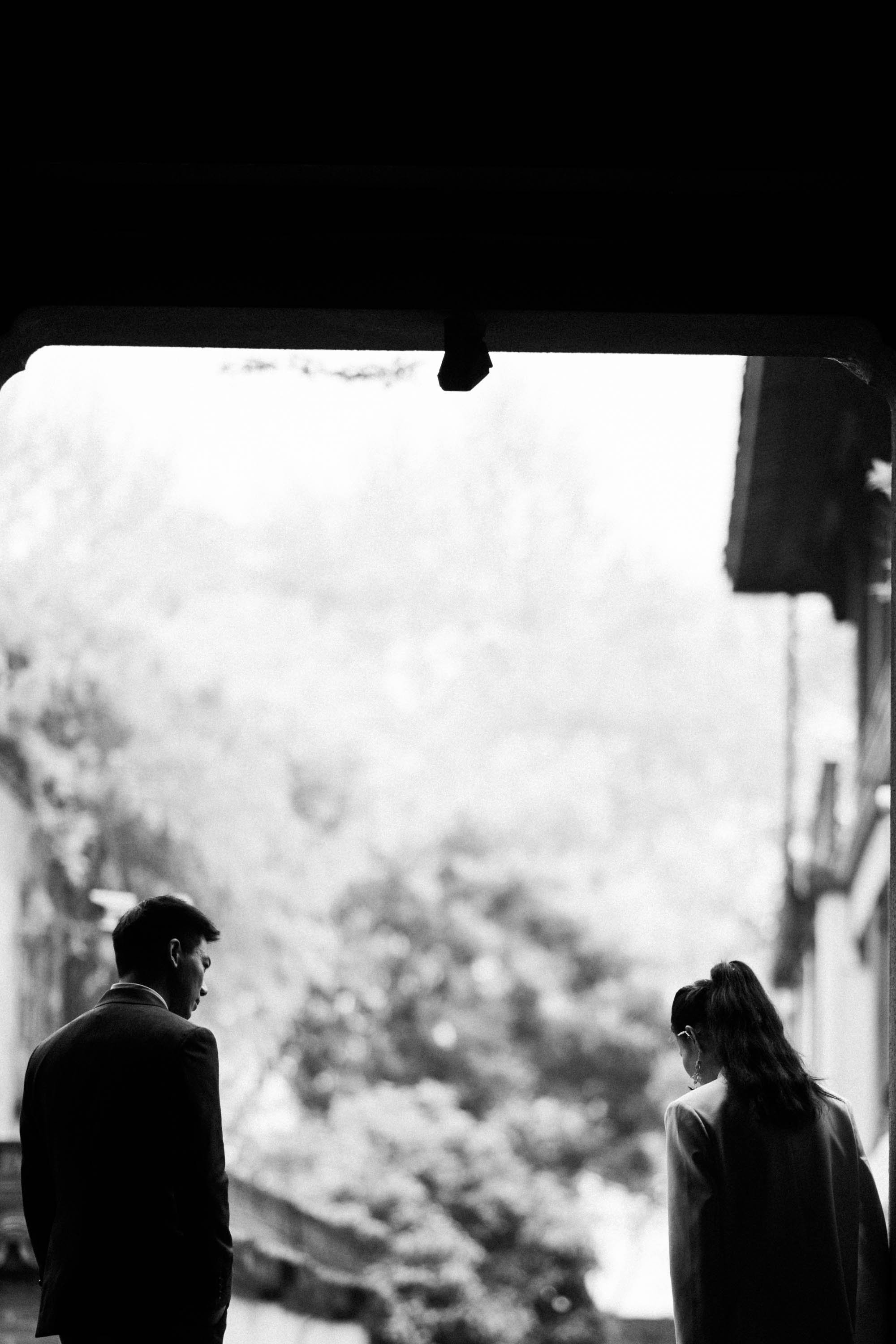 Groom looking back at the bride as they leave the garden.
