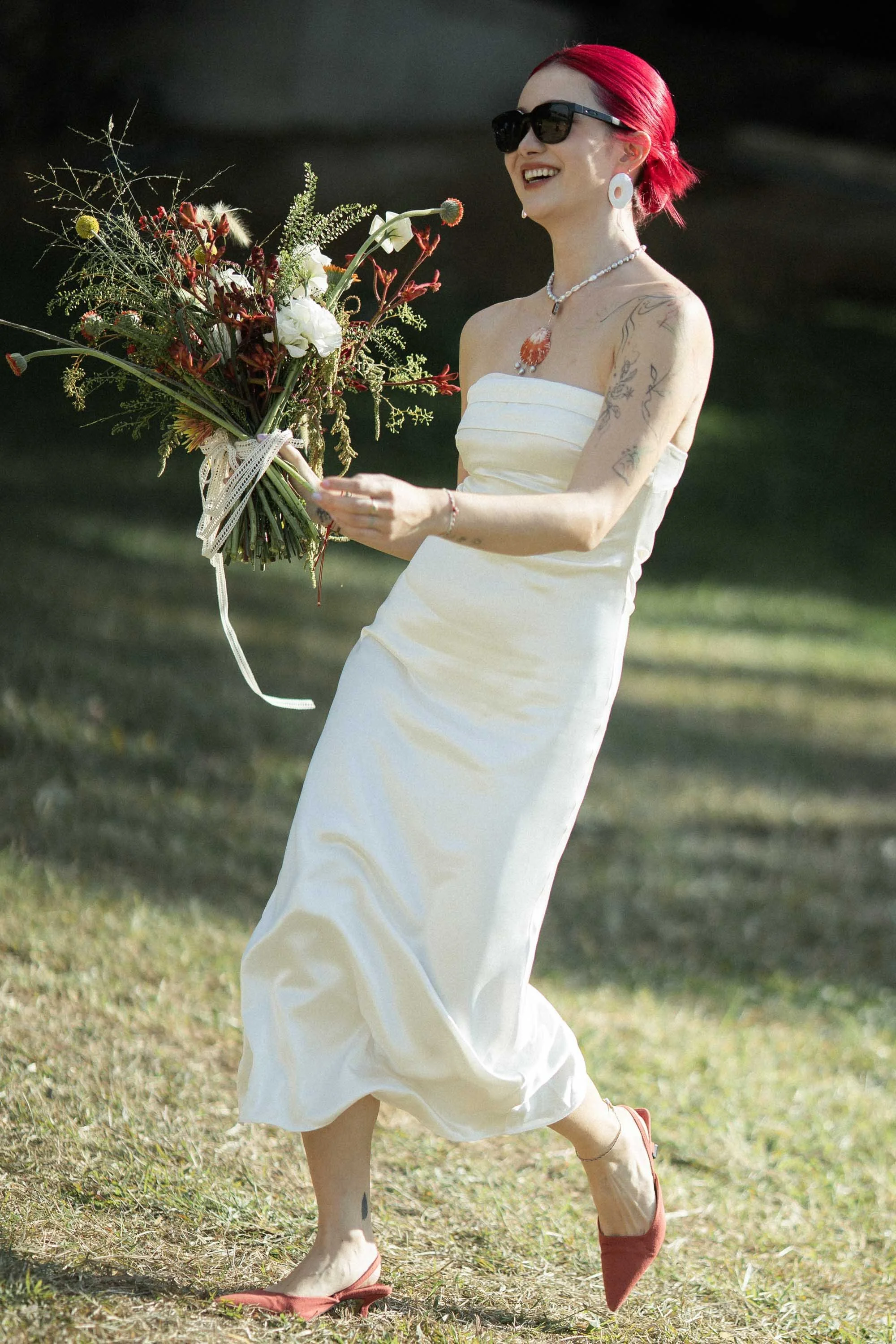 Bride making a joyful entrance while holding her bouquet.