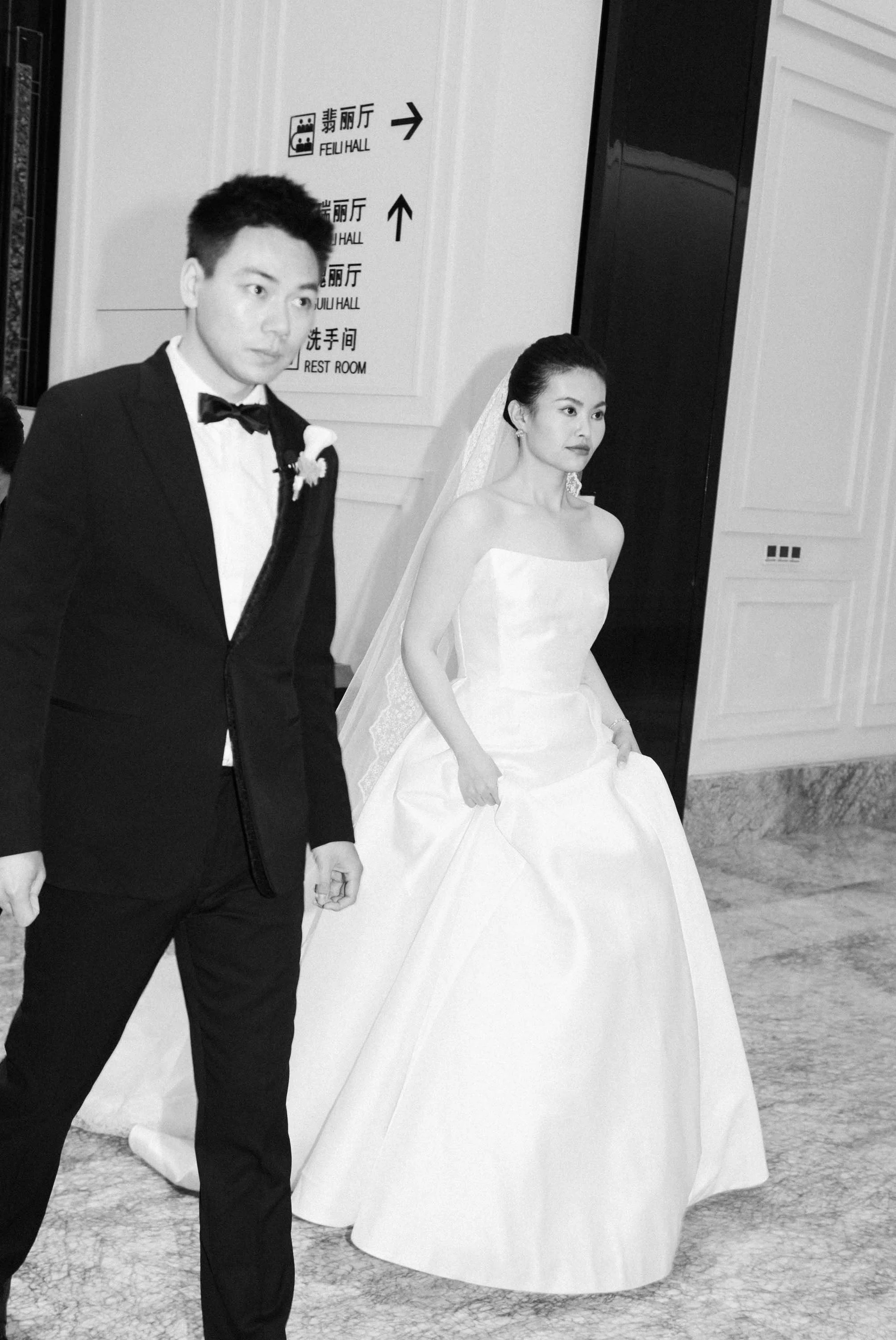 Bride and groom walking toward the reception entrance.