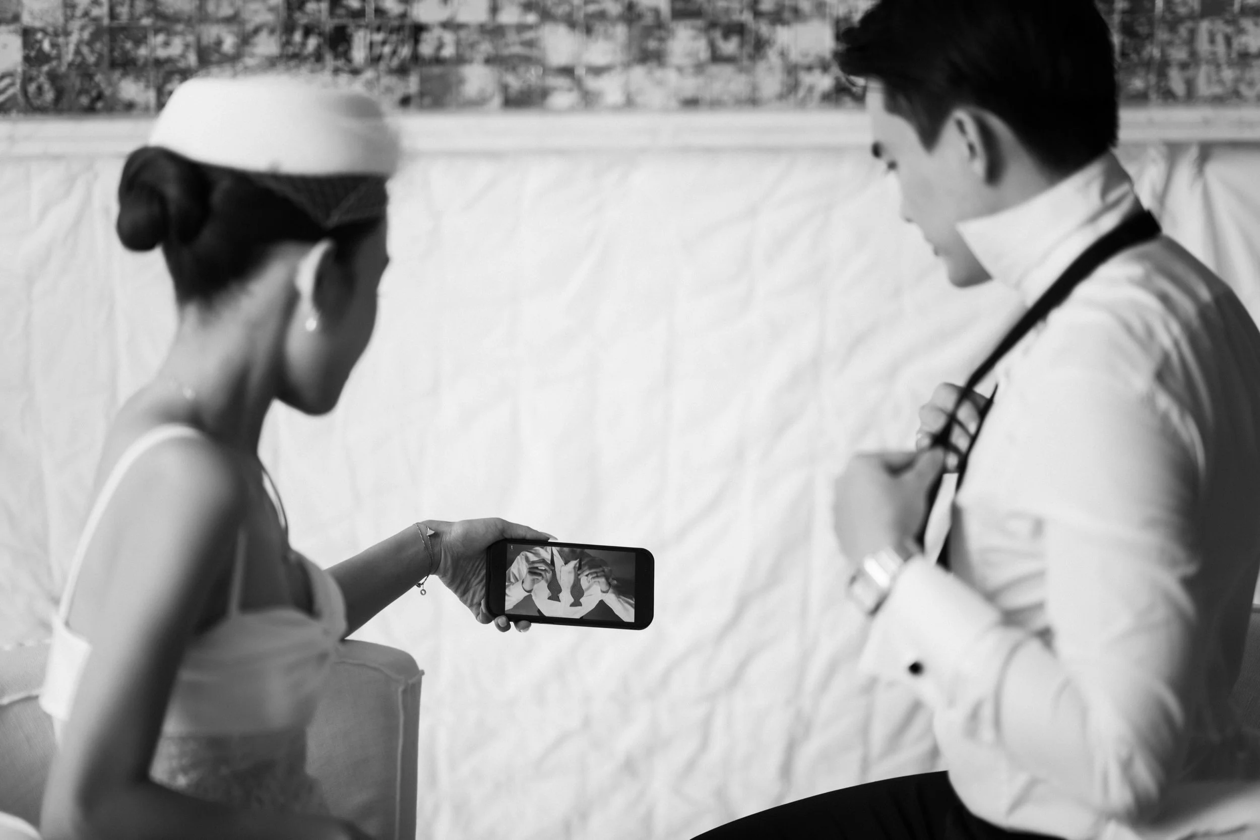 Bride helping the groom tie his bow tie before the ceremony.
